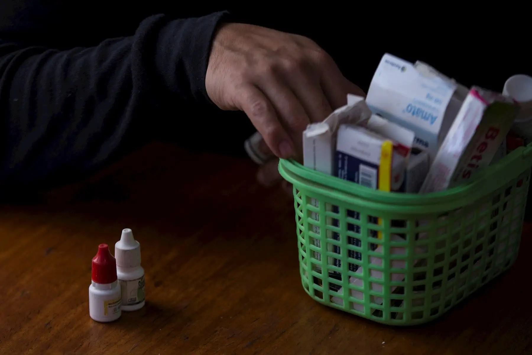 Felipe Elíseo, una de las víctimas de trauma ocular por parte de la policía durante las protestas en Chile, revisa una caja llena de medicamentos, en Santiago. Foto: EFE