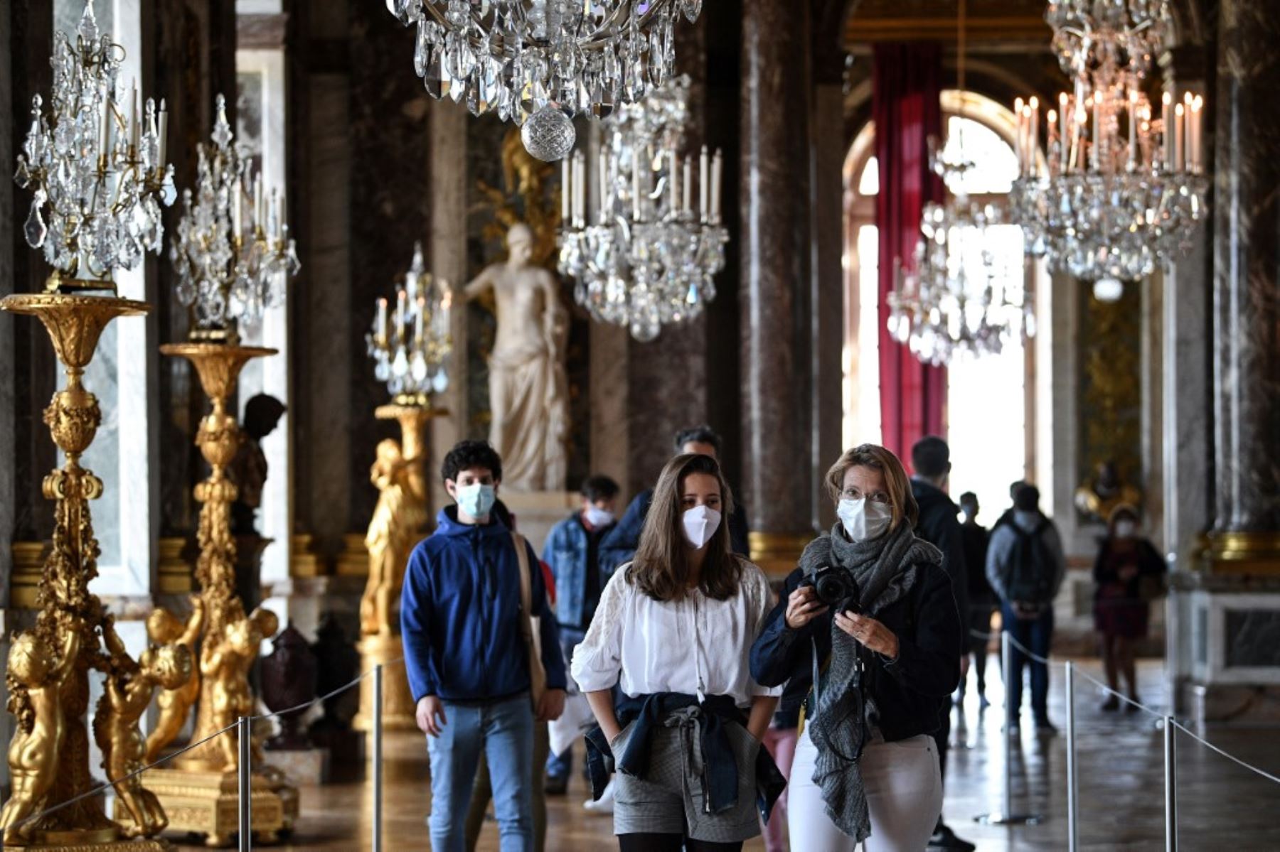 Turistas visitan la el Salón de los Espejos en el emblemático castillo francés de Versalles. Foto: AFP