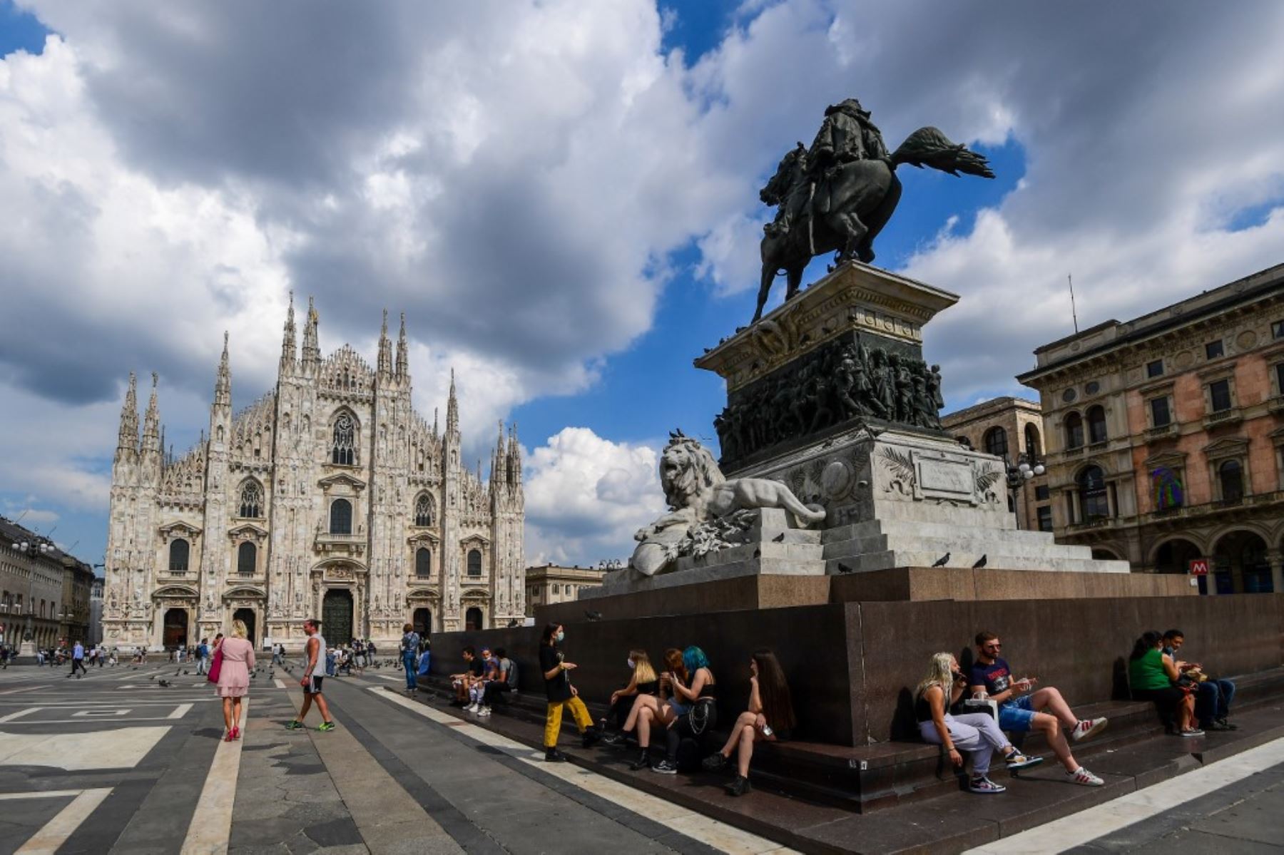La gente se sienta en la Piazza del Duomo junto a la catedral en el centro de Milán, en Italia. Foto: AFP