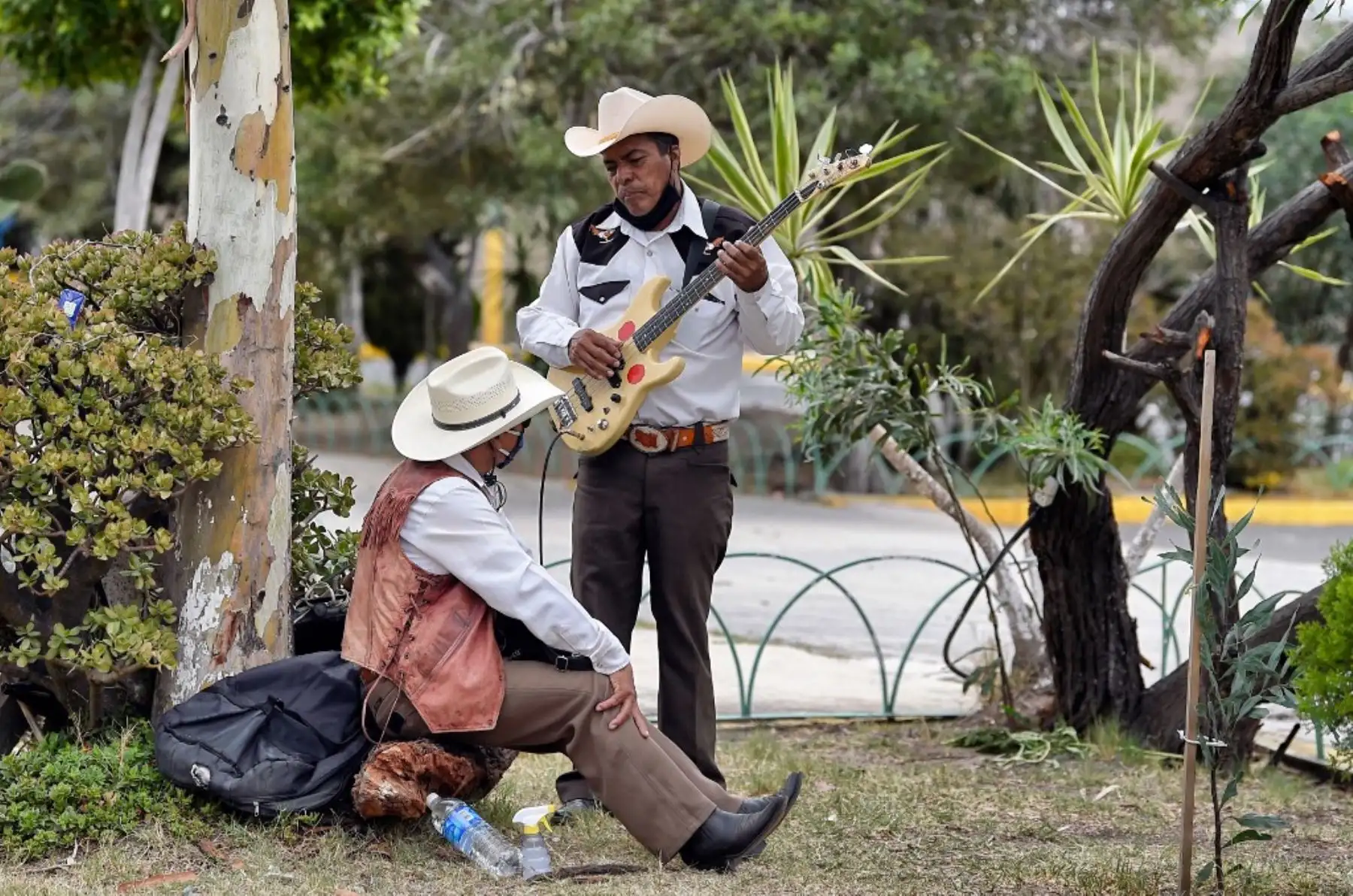 Israel Mundo y Roberto Maldonado, músicos del género musical Norteño hablan mientras esperan un funeral para ofrecer sus servicios en el Panteón Municipal de Ciudad Nezahualcóyotl, en el Estado de México. Foto: AFP