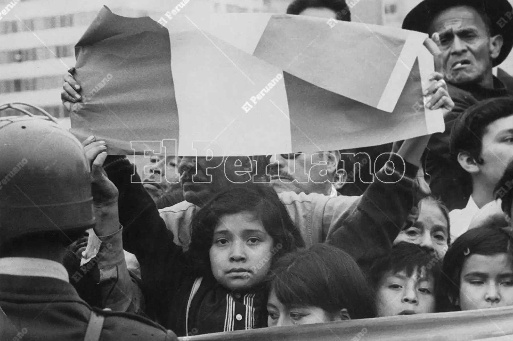 Lima - 7 Junio 1975 / Una niña porta una bandera peruana mientras observa a las delegaciones participantes en la ceremonia por la Jura de la Bandera. Foto: Archivo Histórico de El Peruano .