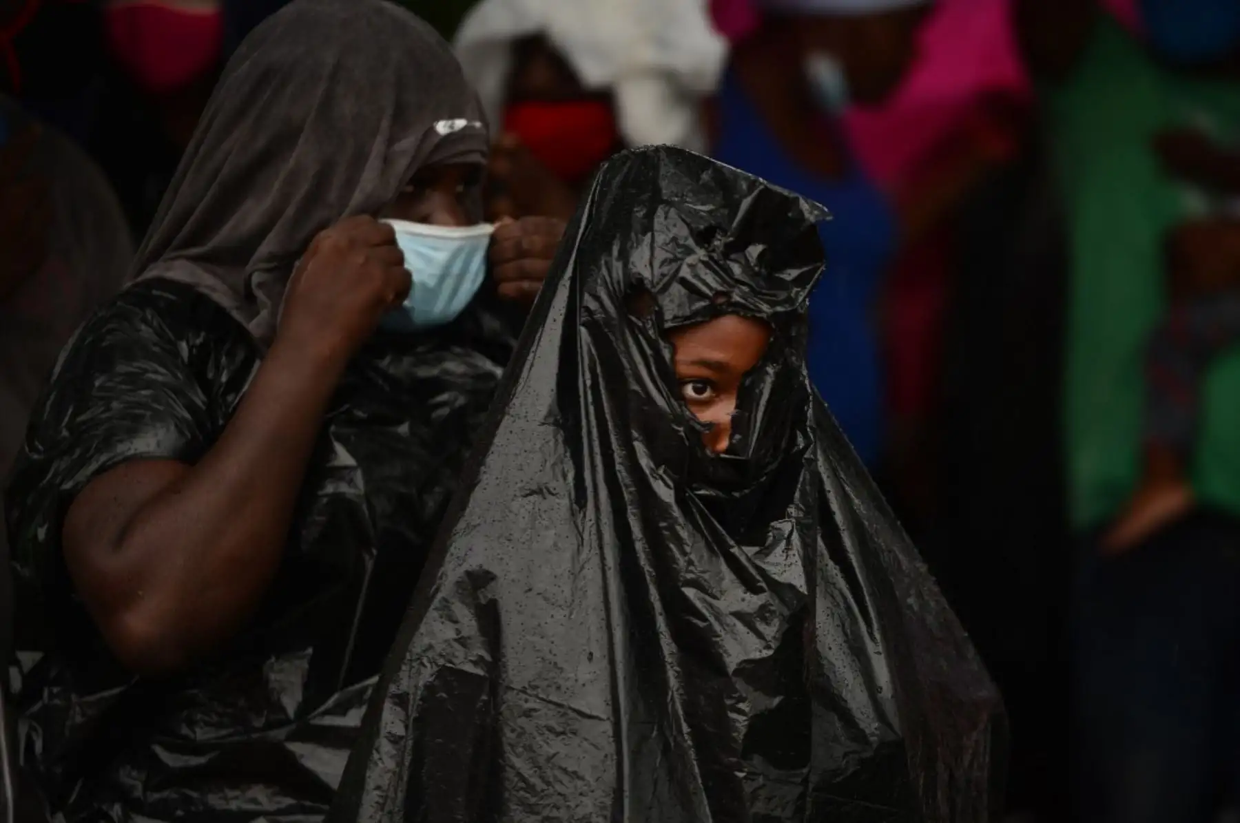 Una migrante usa una bolsa de plástico para protegerse de la lluvia después de ser detenida mientras se dirigía en una caravana a la frontera con Guatemala, a 10 km al sur de Tegucigalpa. Foto: AFP