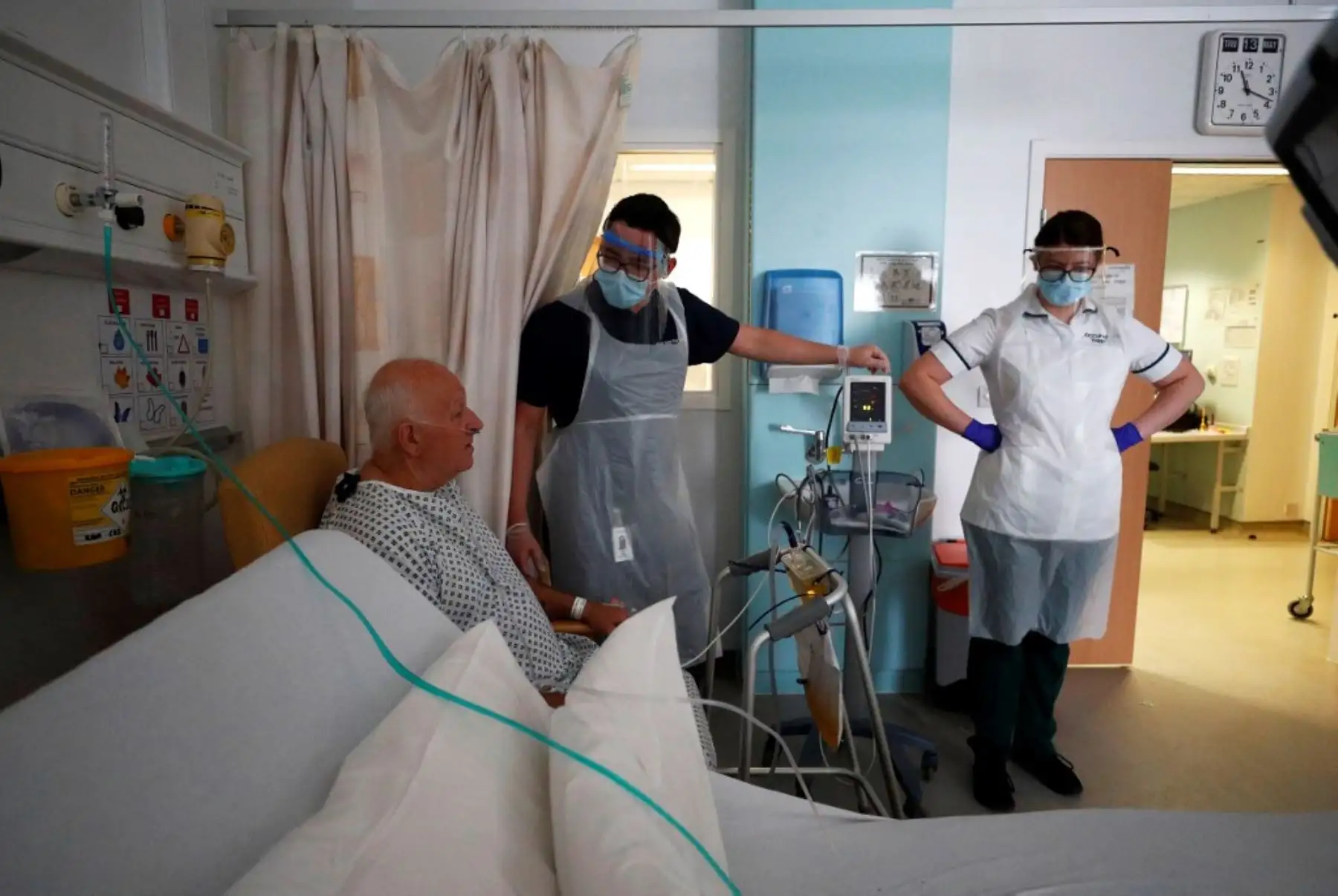 Los terapeutas ocupacionales Jason Smith y Grace Rowan, que usan equipo de protección personal, evalúan al paciente con coronavirus en recuperación Peter Dunn en la sala C22 en el Royal Blackburn Teaching Hospital en Blackburn, noroeste de Inglaterra. Foto: AFP