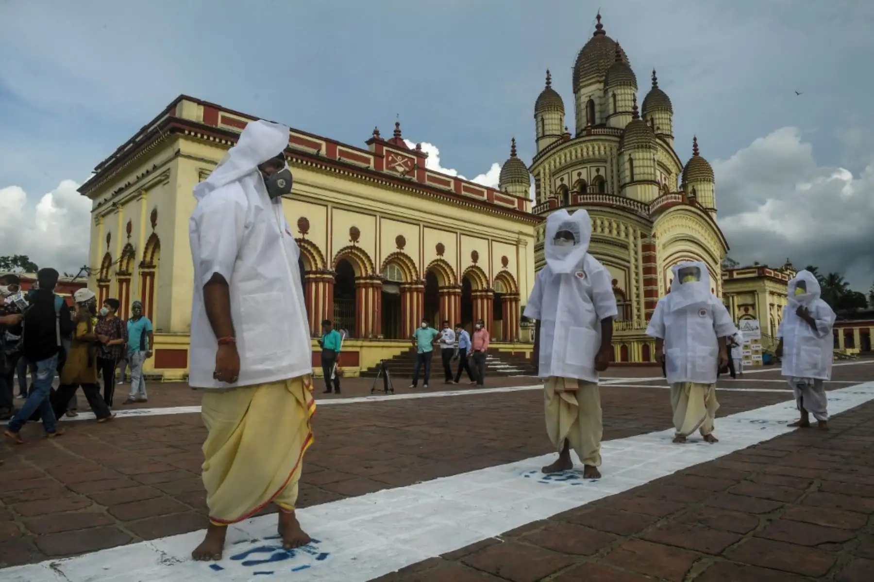 Los sacerdotes hindúes que llevan máscaras faciales y protectores para la cabeza mantienen el distanciamiento social en el Templo Dakshineswar Kali luego de la reapertura de los lugares de culto.
Foto: AFP