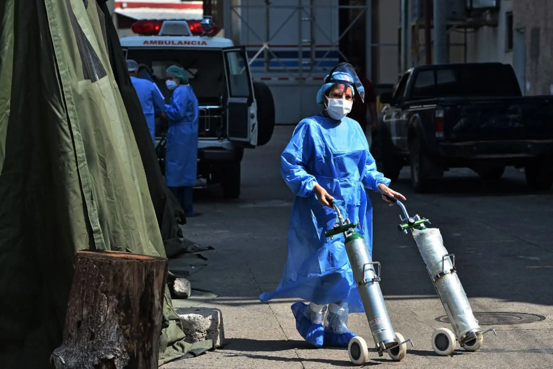Un trabajador de la salud empuja tanques de oxígeno para pacientes infectados con covid-19 asistidos en un hospital de campaña establecido en el patio de un hospital en Tegucigalpa.
Foto: AFP
