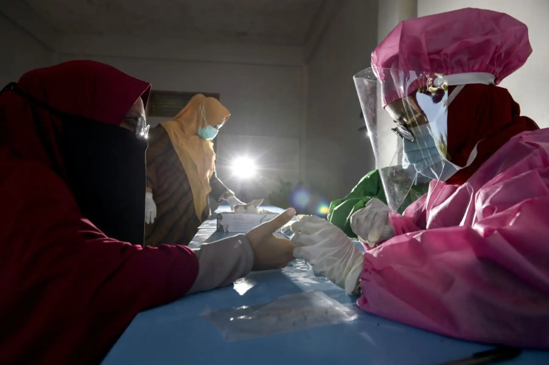 Los trabajadores de la salud que usan equipo de protección llevan a cabo una prueba de muestra de sangre en estudiantes para el coronavirus  en un internado islámico en Sibreh, provincia de Aceh.
Foto: AFP