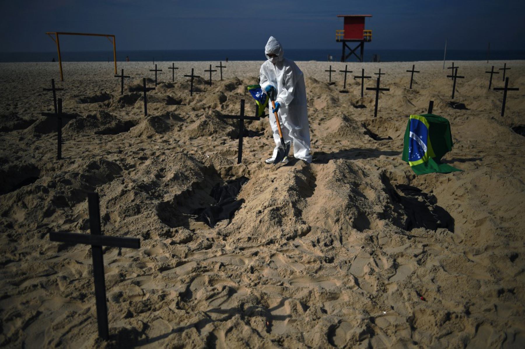 Activistas de la ONG brasileña Rio de Paz (Peace Rio) cavan 100 tumbas simuladas en la playa de Copacabana que simbolizan las muertes por el coronavirus en Río de Janeiro, Brasil. Foto: AFP