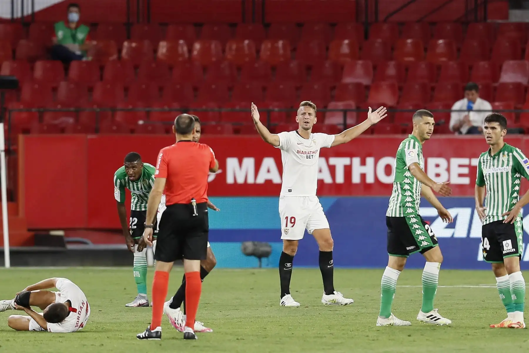 El delantero neerlandés del Sevilla FC Luuk de Jong  protesta al árbitro Mateu Lahoz tras una entrada a su compañero Joan Jordán , durante el partido de la jornada 28 de Liga que Sevilla FC y Real Betis juegan  en el estadio Ramón Sánchez-Pizjuán, en Sevilla.
Foto: EFE