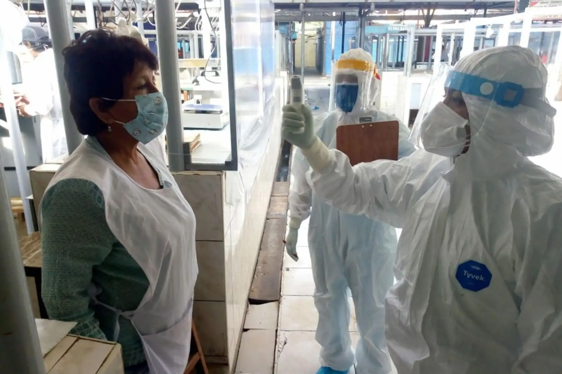 Una comerciante de Chiclayo pasa por un control de temperatura para descartar fiebre, una de las manifestaciones del covid-19.
