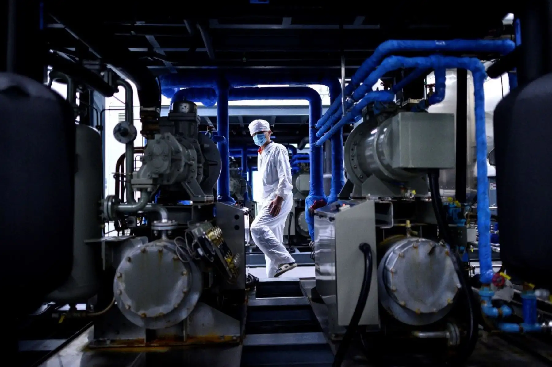 Un trabajador con un traje de protección camina en un laboratorio de la compañía Yisheng Biopharma. Foto: AFP