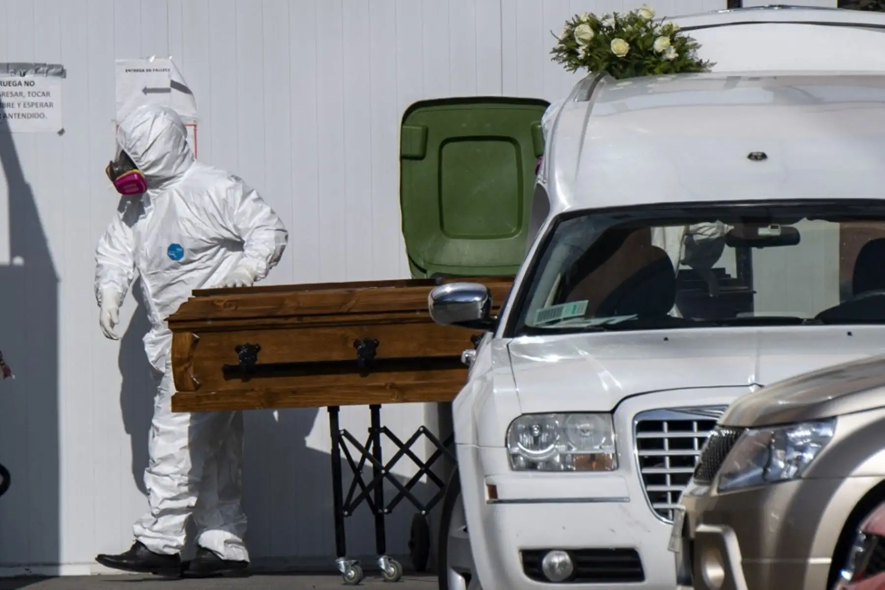 Un trabajador de la salud transfiere un ataúd fuera de la morgue del Hospital Público de San José, en Santiago. Foto: AFP