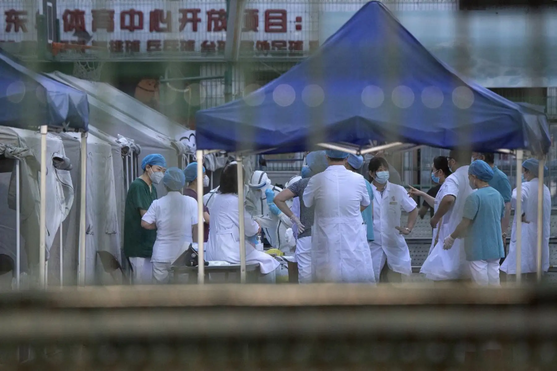 Los trabajadores médicos que usan traje de protección son vistos en el centro deportivo de Dongdan para recoger pruebas de hisopos para detectar el nuevo coronavirus  en Beijing.
Foto: AFP