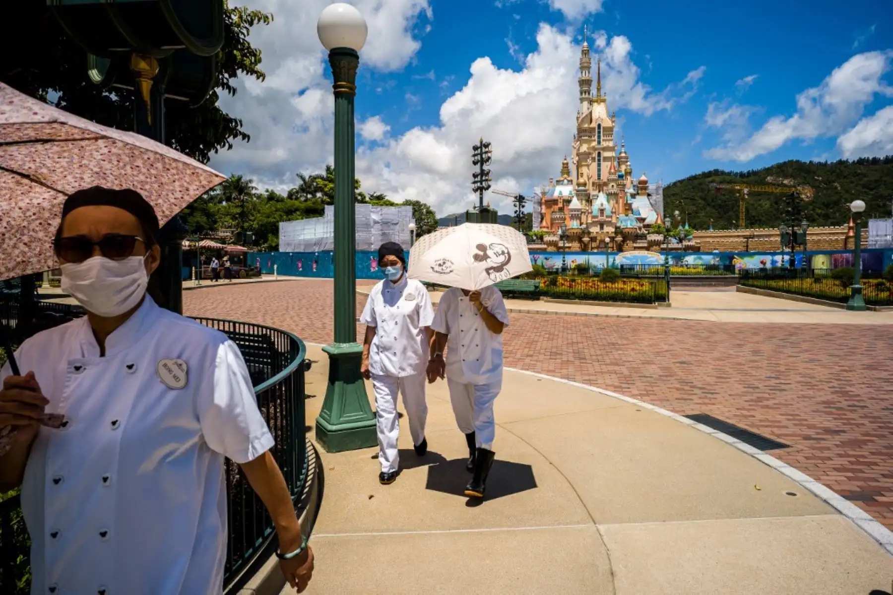 Trabajadores caminan por el área de Disneyland de Hong Kong el 17 de junio de 2020, un día antes de que las puertas del parque temático vuelvan a abrir después de casi cinco meses de cierre por coronavirus. Foto: AFP