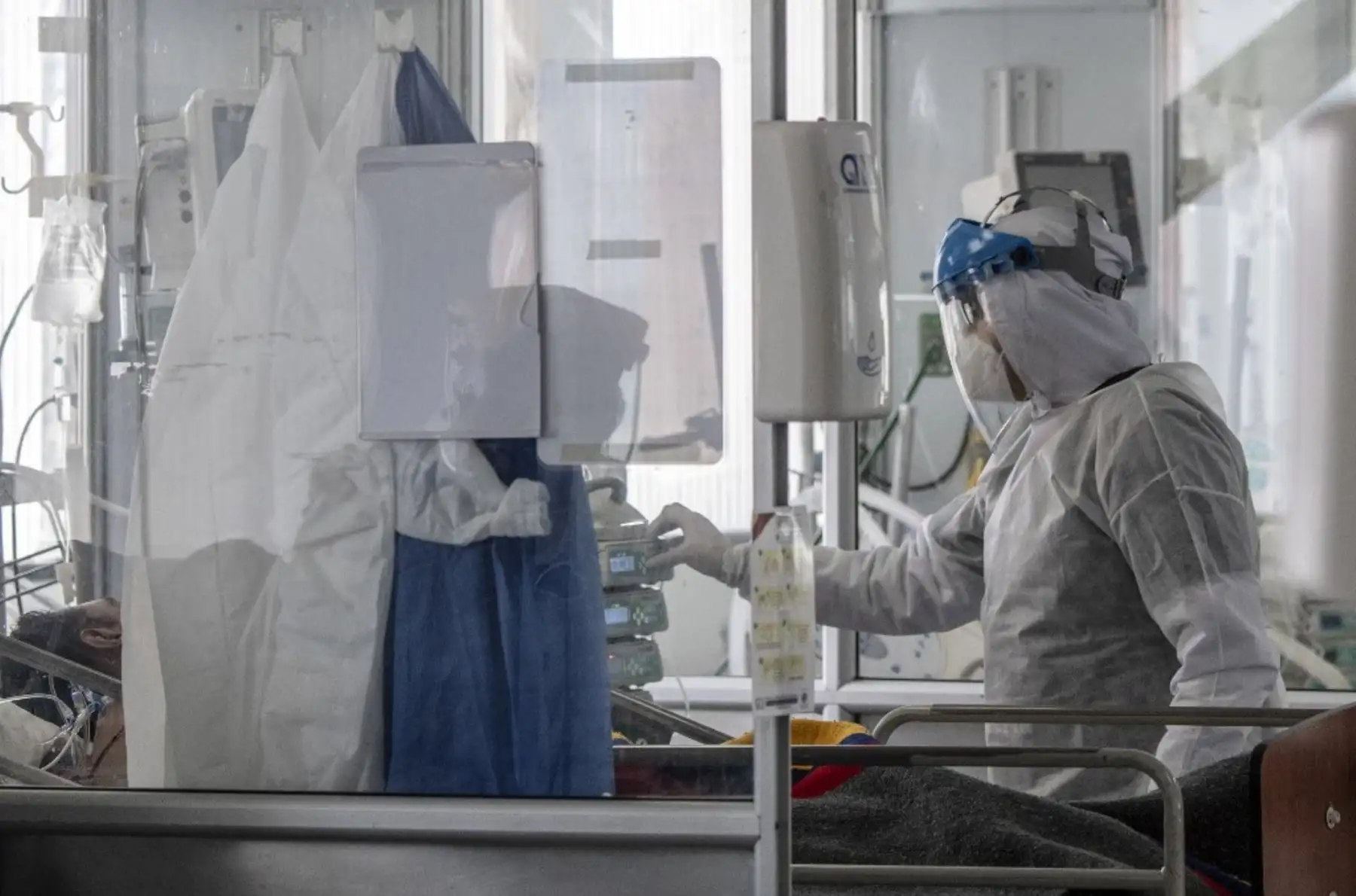 El personal de salud que usa trajes protectores contra la propagación del COVID-19 ayuda a un paciente en la unidad de cuidados intensivos en el Hospital Público El Tunal, en Bogotá. Foto: AFP
