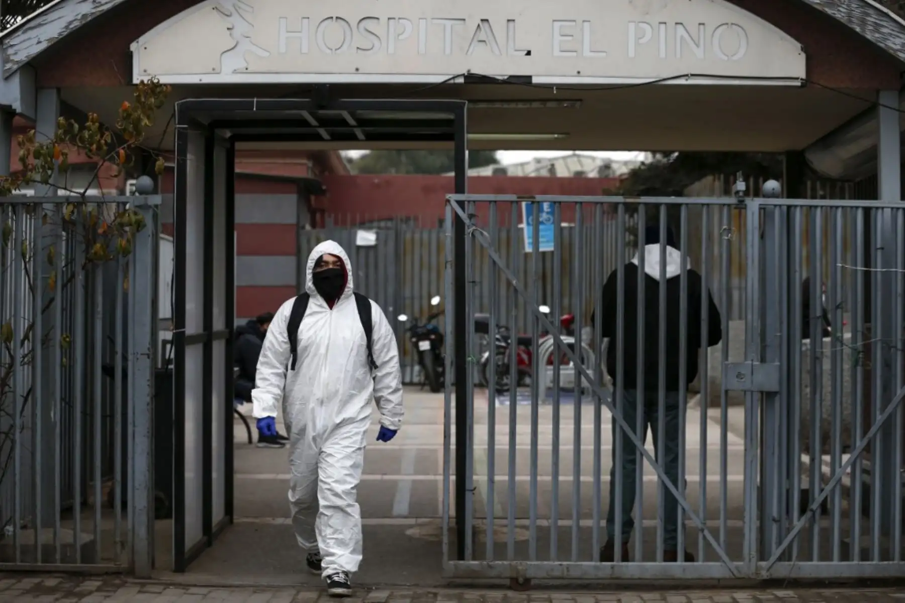 Un hombre cubierto con implementos de bioseguridad sale del hospital El Pino, en Santiago del Chile. Foto: AFP