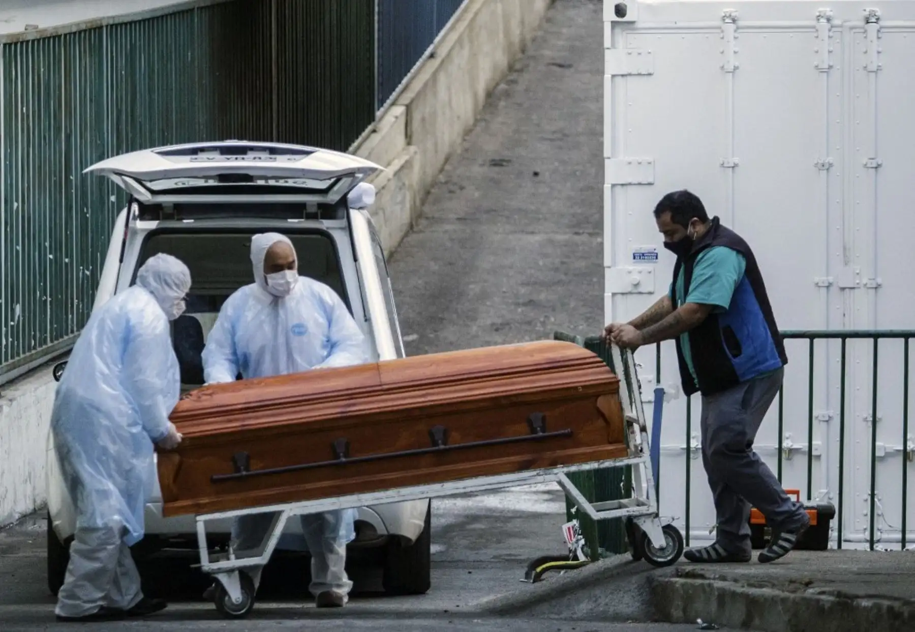 Los empleados de una funeraria llevan el ataúd de una víctima de COVID-19 a un vehículo, en las afueras del Hospital Carlos Van Buren en Valparaíso, Chile. Foto: AFP