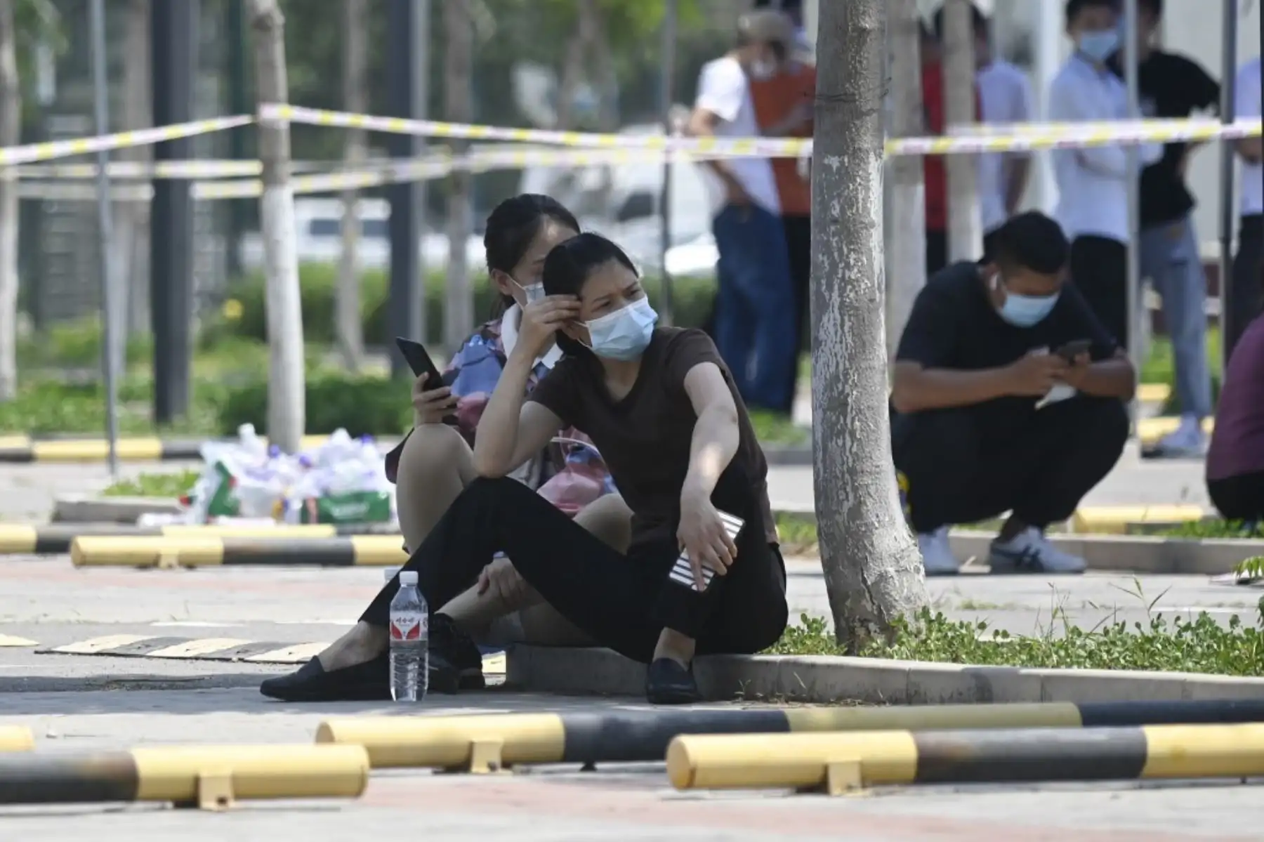 Una mujer con una máscara facial espera para hacerse una prueba de hisopo para el coronavirus COVID-19 en un sitio de prueba en Beijing. Foto: AFP