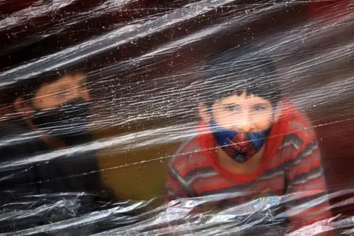 Un niño mira un campamento improvisado donde los inmigrantes venezolanos desempleados y sin hogar permanecen durante la pandemia de coronavirus, en Bogotá, Colombia. Foto: AFP