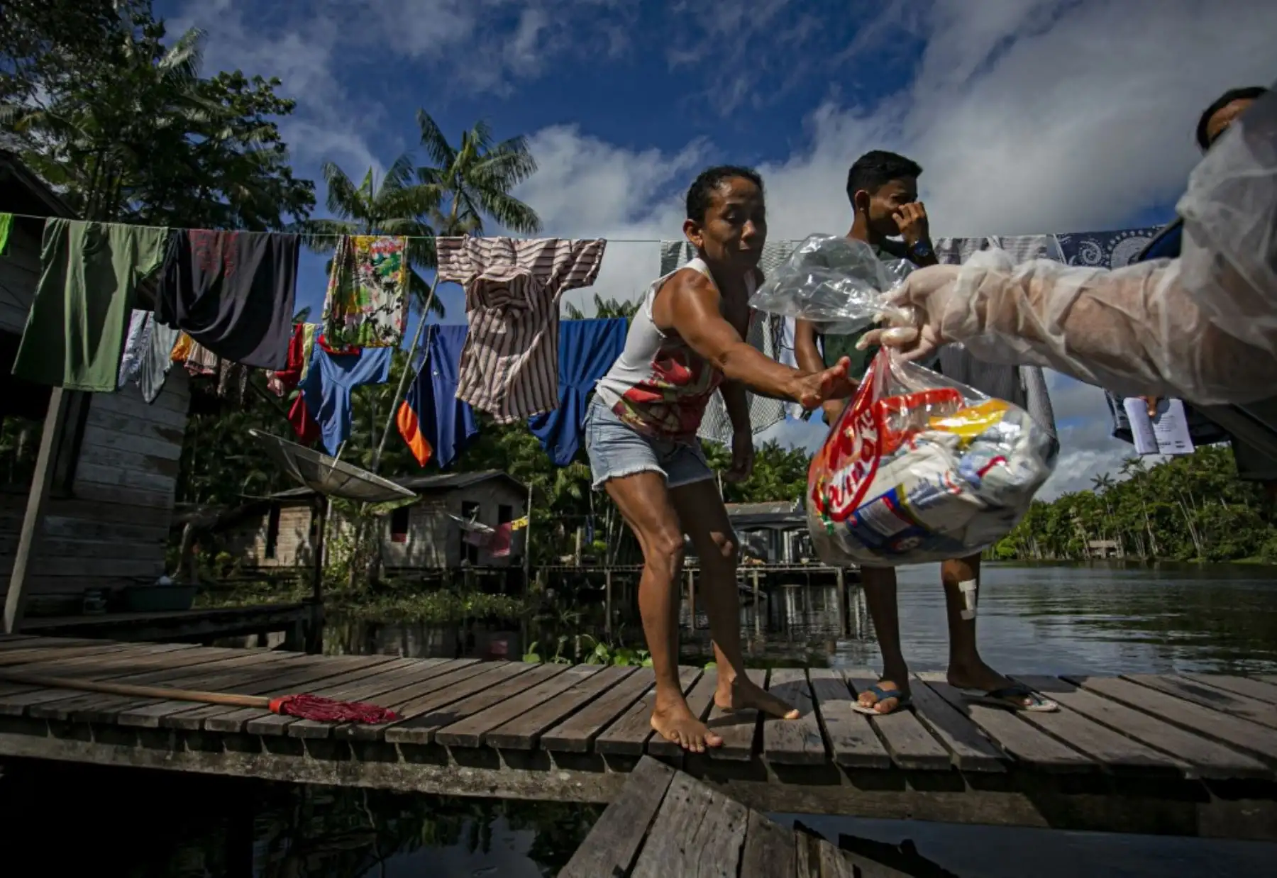 Un miembro del personal del Ministerio de Educación usa un traje de protección mientras entrega kits de almuerzo escolar gratuitos para los locales necesitados en Megalco, estado de Pará, Brasil. Foto: AFP