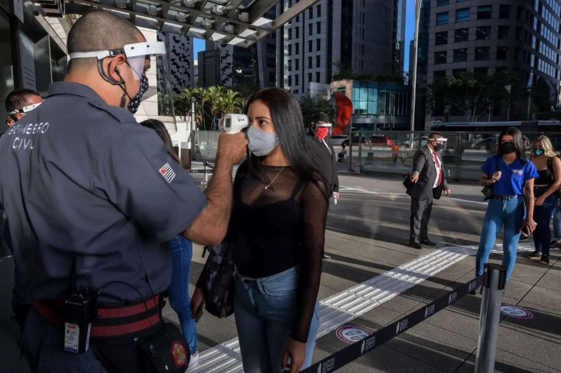 Se verifica la temperatura de un cliente cuando ingresa a un centro comercial después de su reapertura, en la Avenida Paulista, en Sao Paulo, Brasil. Foto: AFP