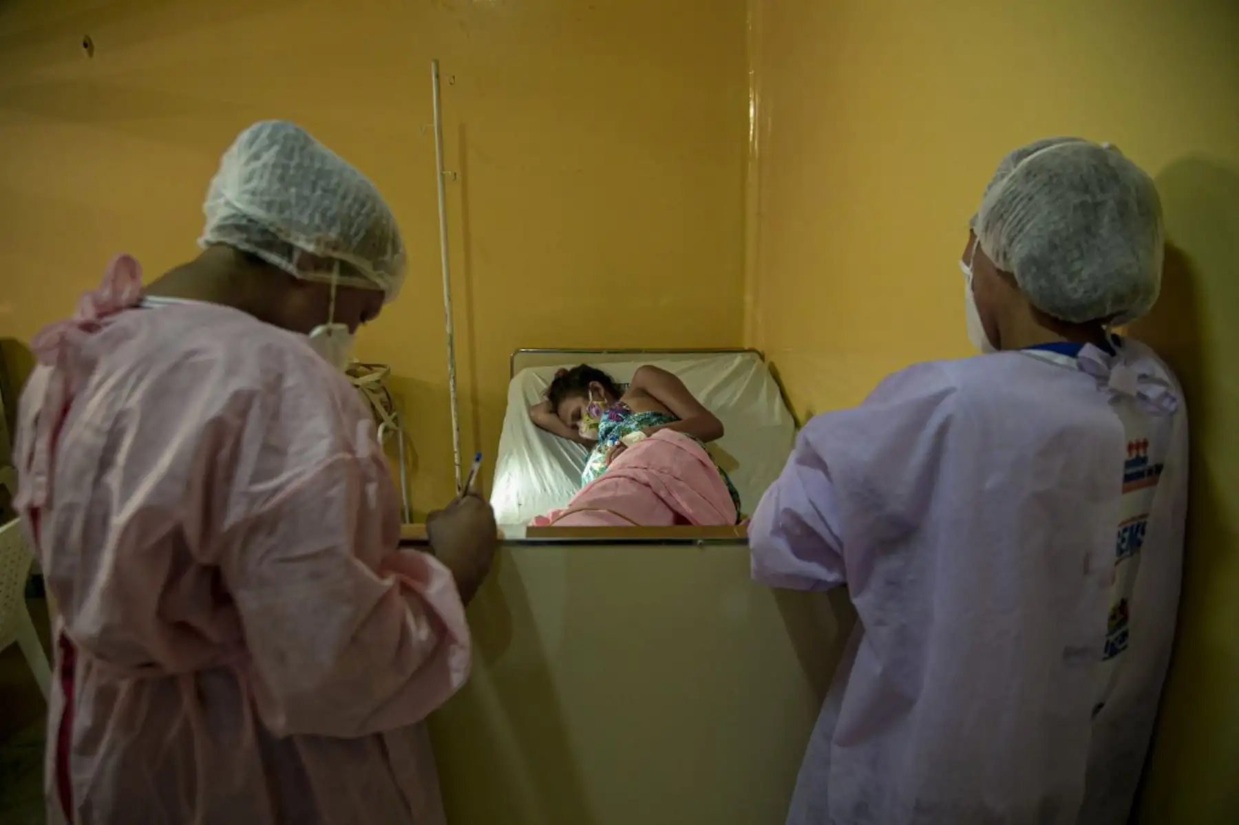 Se ve a una paciente con síntomas de covid-19 que tiene contracciones mientras espera la preparación de una habitación para tener a su bebé, en el Hospital Municipal de Melgaco en la ciudad de Melgaco. Foto: AFP