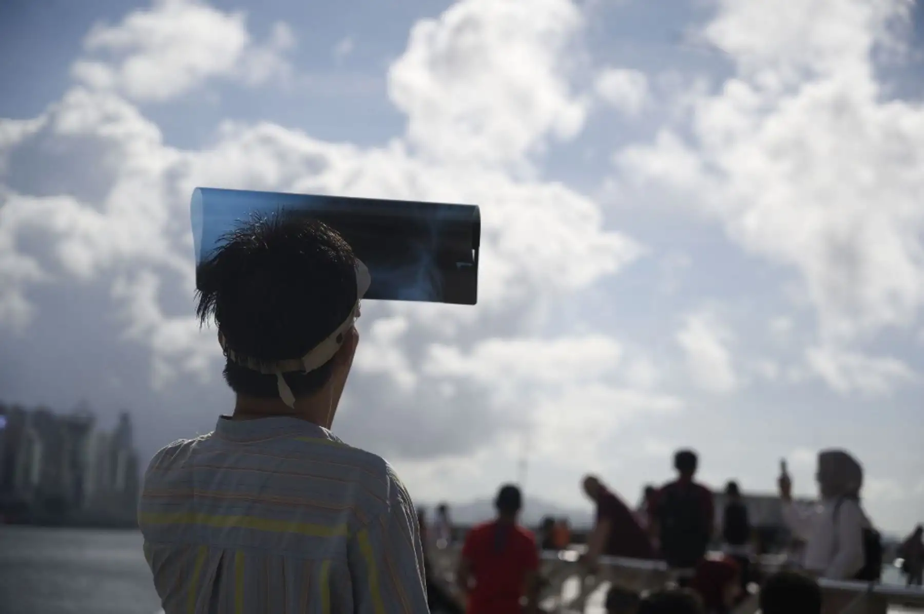 Un hombre observa un eclipse solar parcial a través de una película de rayos X en Hong Kong. Foto: AFP