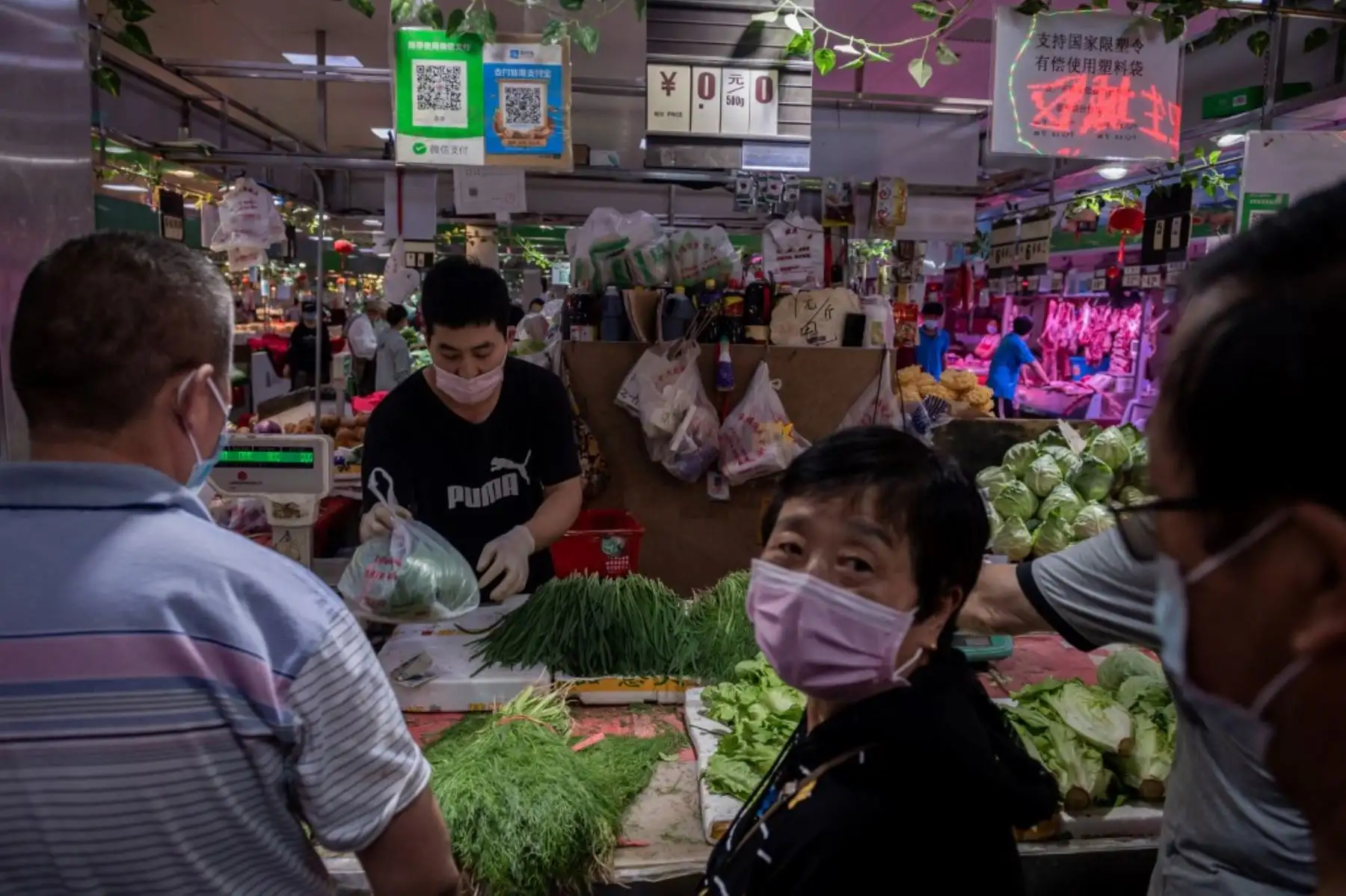 Un vendedor vende vegetales en su puesto en un mercado en Pekín. Foto: AFP