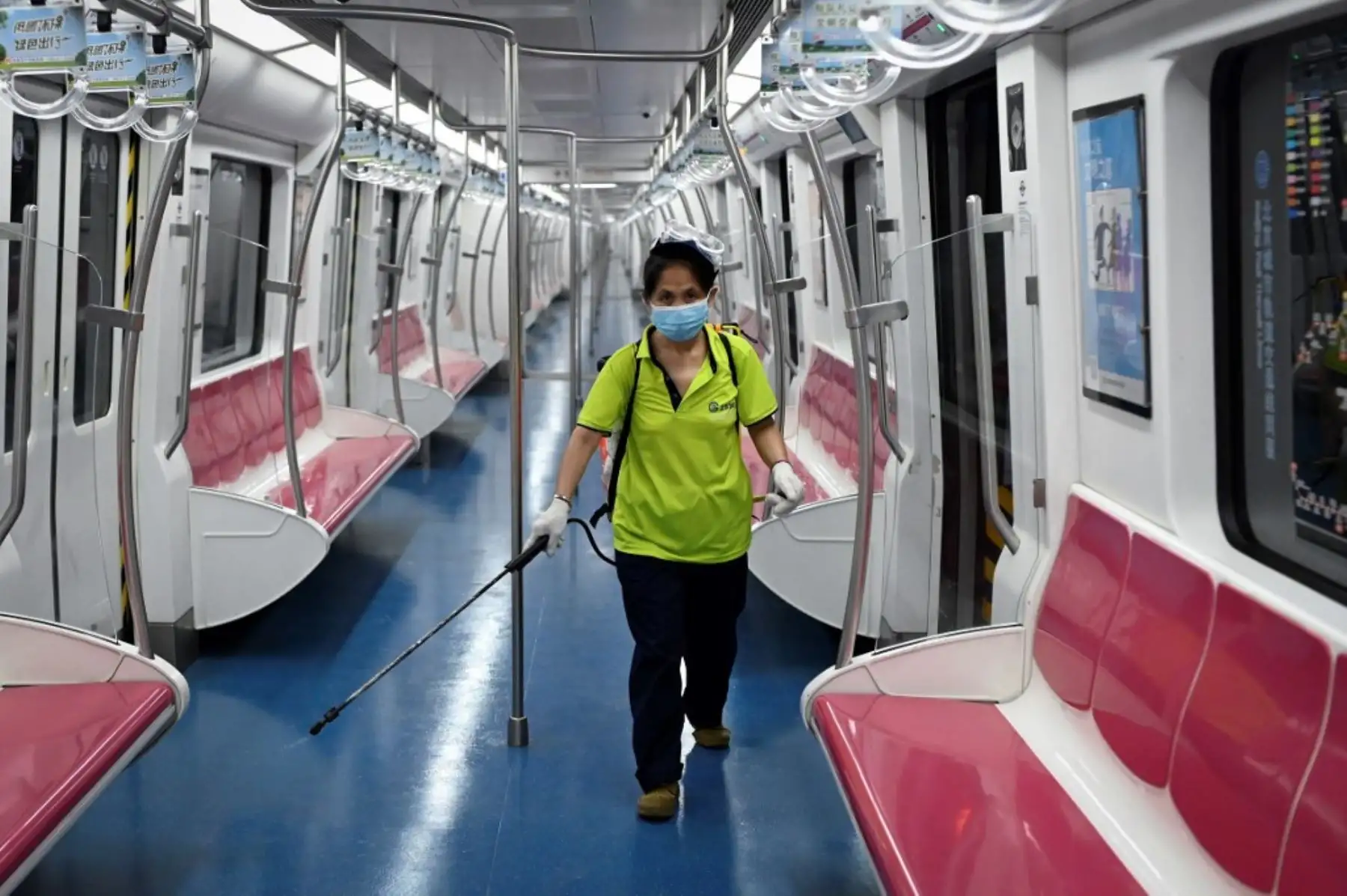 Un miembro del personal rocía desinfectante en un tren en una estación de metro en Pekín. Foto: AFP