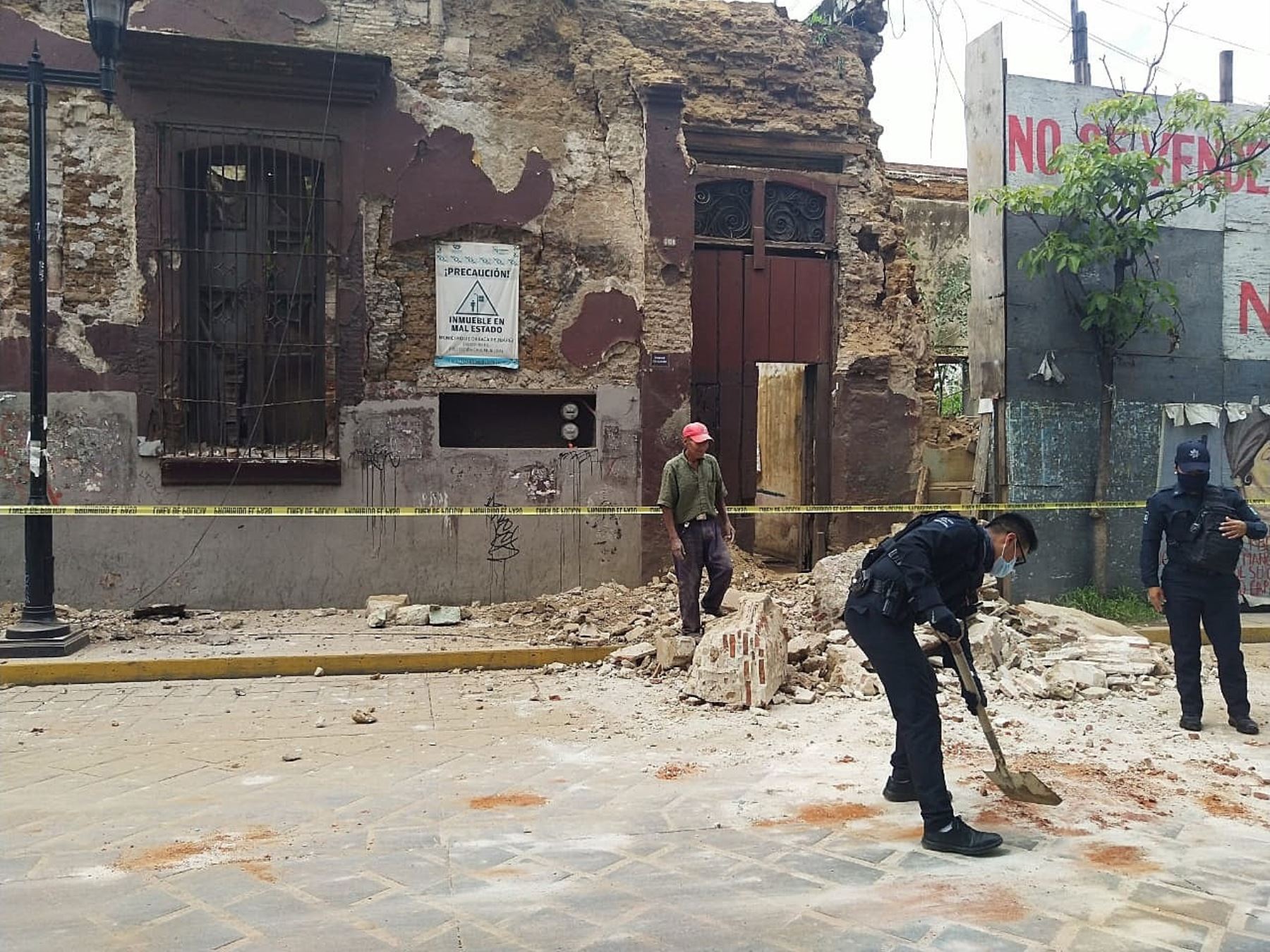 Policías y elementos de Protección Civil levantan parte de una barda derrumbada en la ciudad de Oaxaca (México). Foto: EFE