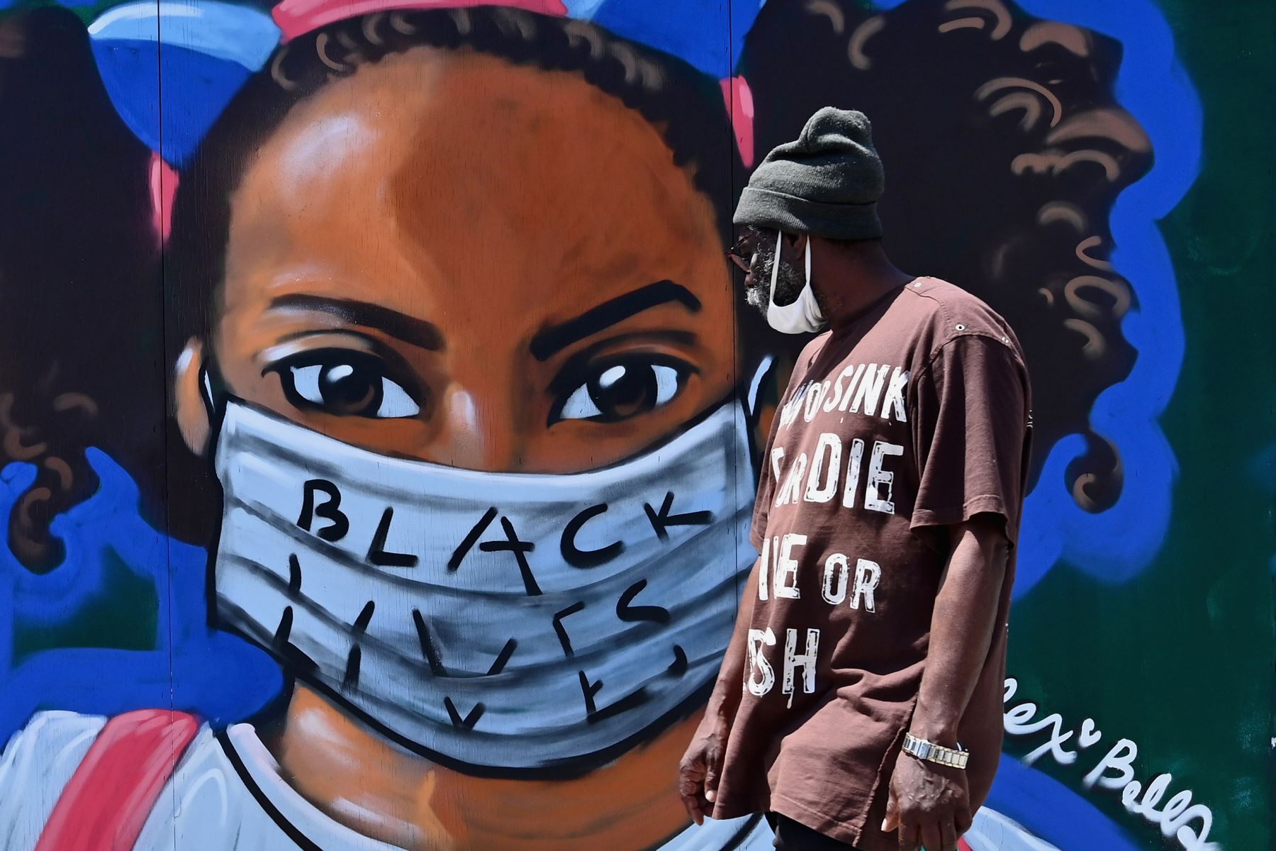 Una persona pasa frente a un mural callejero del artista Lexi Bella en el distrito de Brooklyn de la ciudad de Nueva York. Foto: AFP