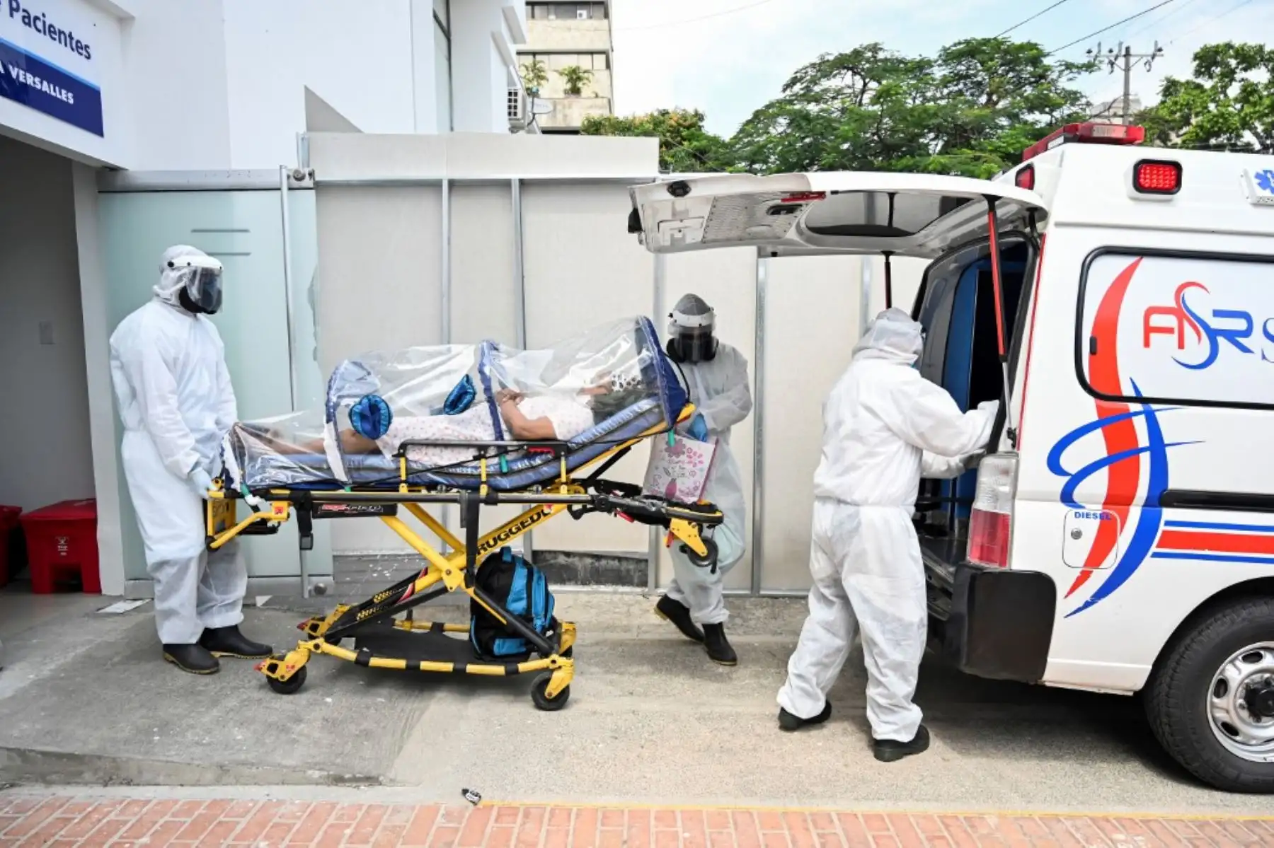 Los trabajadores de la salud trasladan a una paciente de coronavirus en la clínica Versalles en la ciudad de Cali.
Foto: AFP