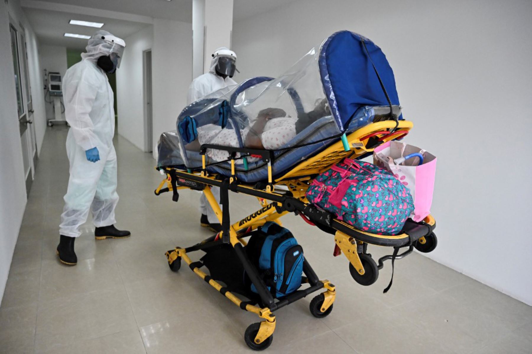 Los trabajadores de la salud trasladan a una paciente de coronavirus en  la clínica Versalles  en la ciudad de  Cali.Foto: AFP