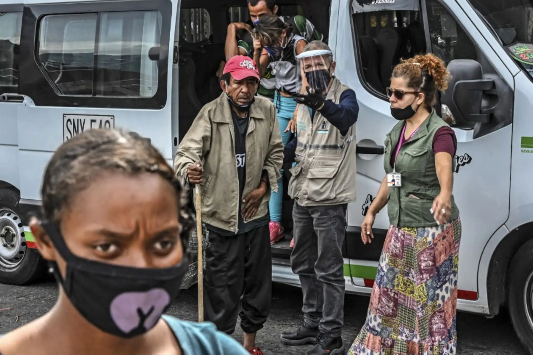 Las personas sin hogar se bajan de una camioneta que los transporta a un área provista para que se duchen y coman en medio de la pandemia  covid -19 en Medellín.
Foto: AFP