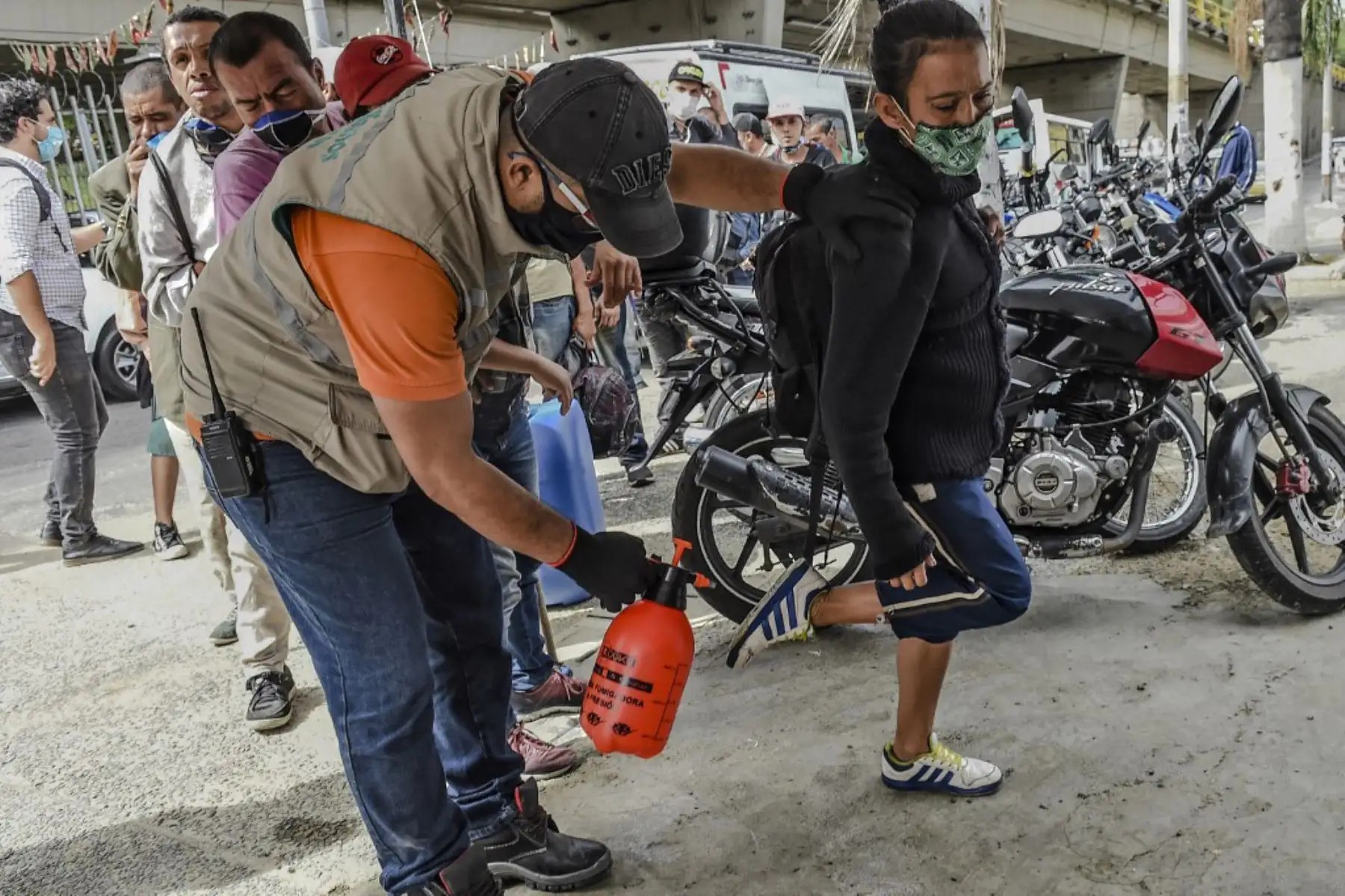 Un empleado desinfecta los zapatos de una mujer antes de que entre en un área provista para que las personas sin hogar se duchen y coman en medio de la pandemia covid-19 en Medellín.
Foto: AFP
