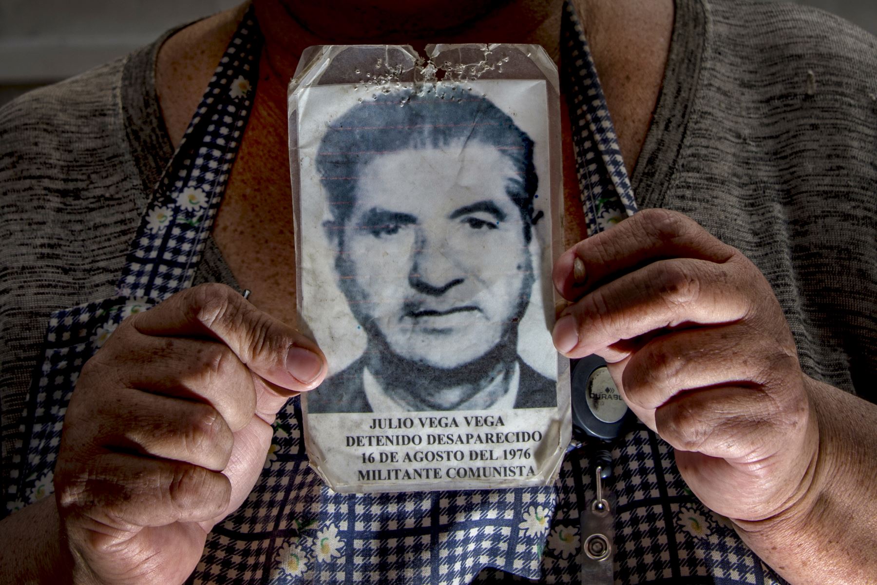 Marisol Vega, nieta de Julio Vega, quien desapareció en 1976 durante la dictadura militar de Augusto Pinochet, posa sosteniendo una foto de su abuelo. Foto: AFP