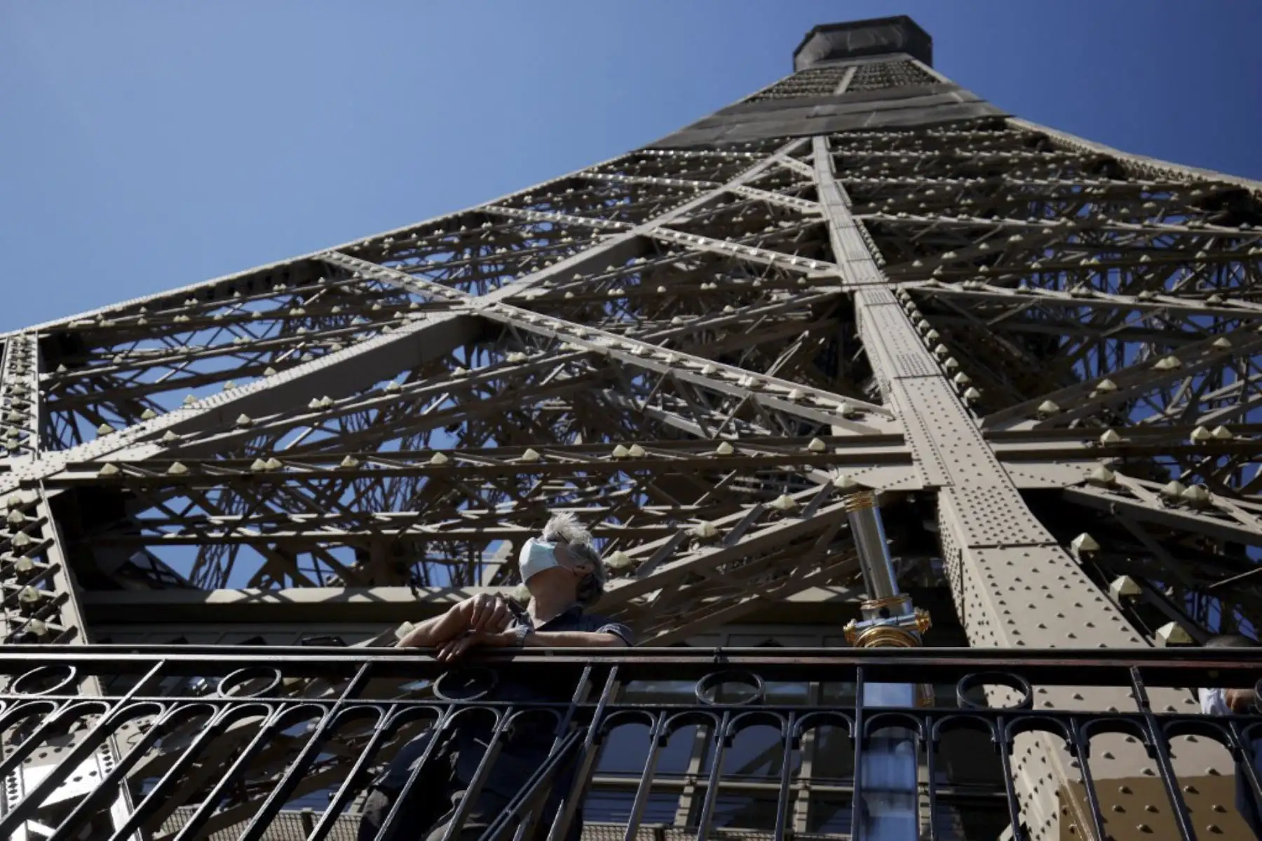 Un visitante que lleva una máscara protectora admira la vista desde la Torre Eiffel. Foto: AFP