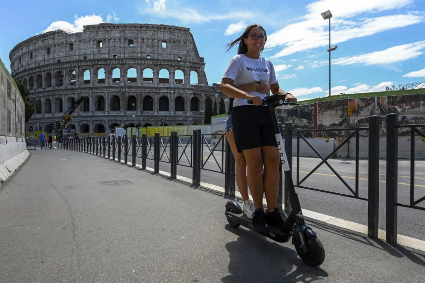 Los jóvenes montan un scooter eléctrico cerca del Coliseo en Roma, mientras el país alivia su bloqueo para frenar la propagación de la infección por covid-19-Foto: AFP
