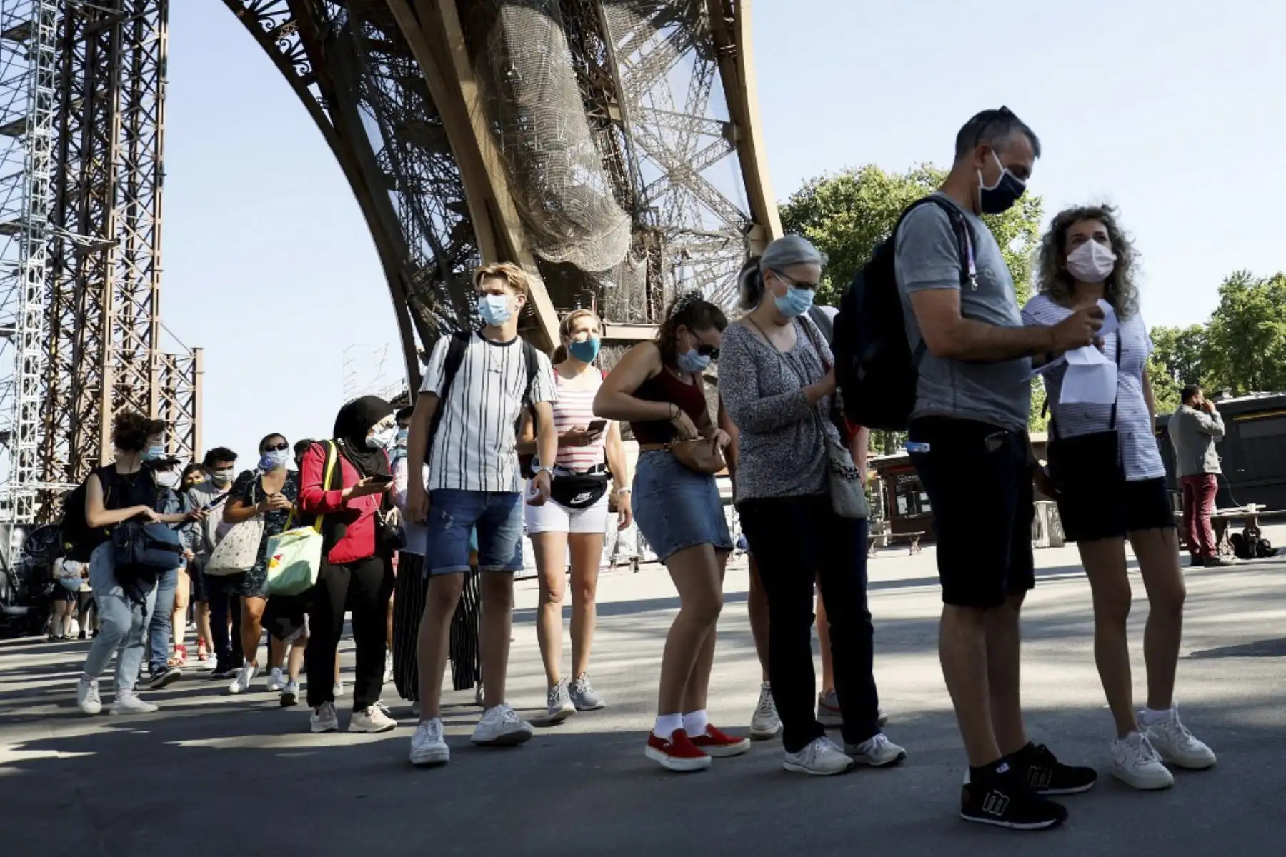 Los visitantes que llevan máscaras protectoras hacen cola mientras esperan la reapertura parcial de la Torre Eiffel. Foto:AFP