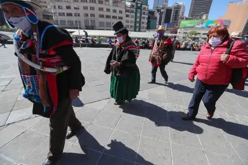 Indígenas aymaras caminan en una plaza este jueves, a tres meses de la cuarentena decretada por la pandemia de covid-19, en La Paz (Bolivia). Foto: EFE
