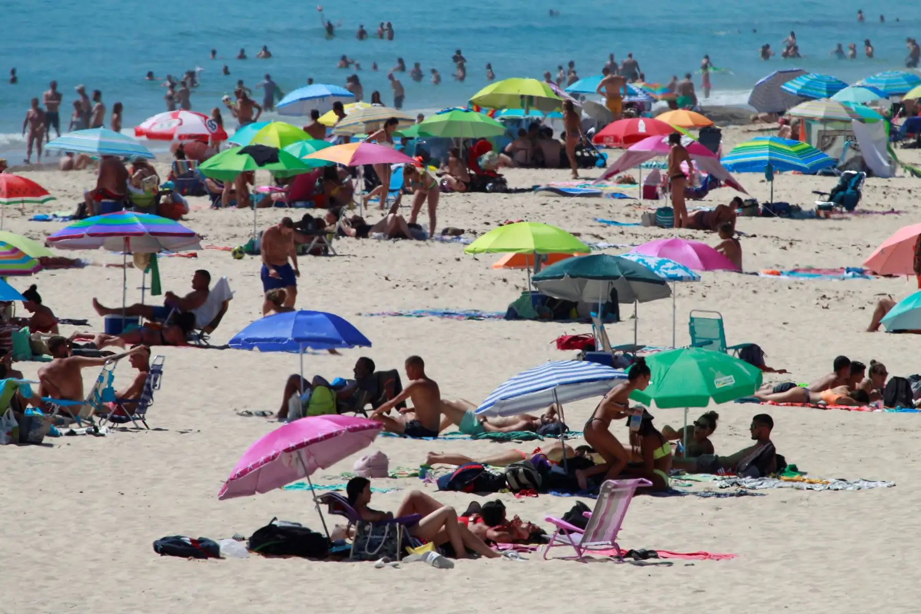 Decenas de personas disfrutan de un soleado día en la playa de Los Lances, en Tarifa (Cádiz), este domingo, primer fin de semana de la 