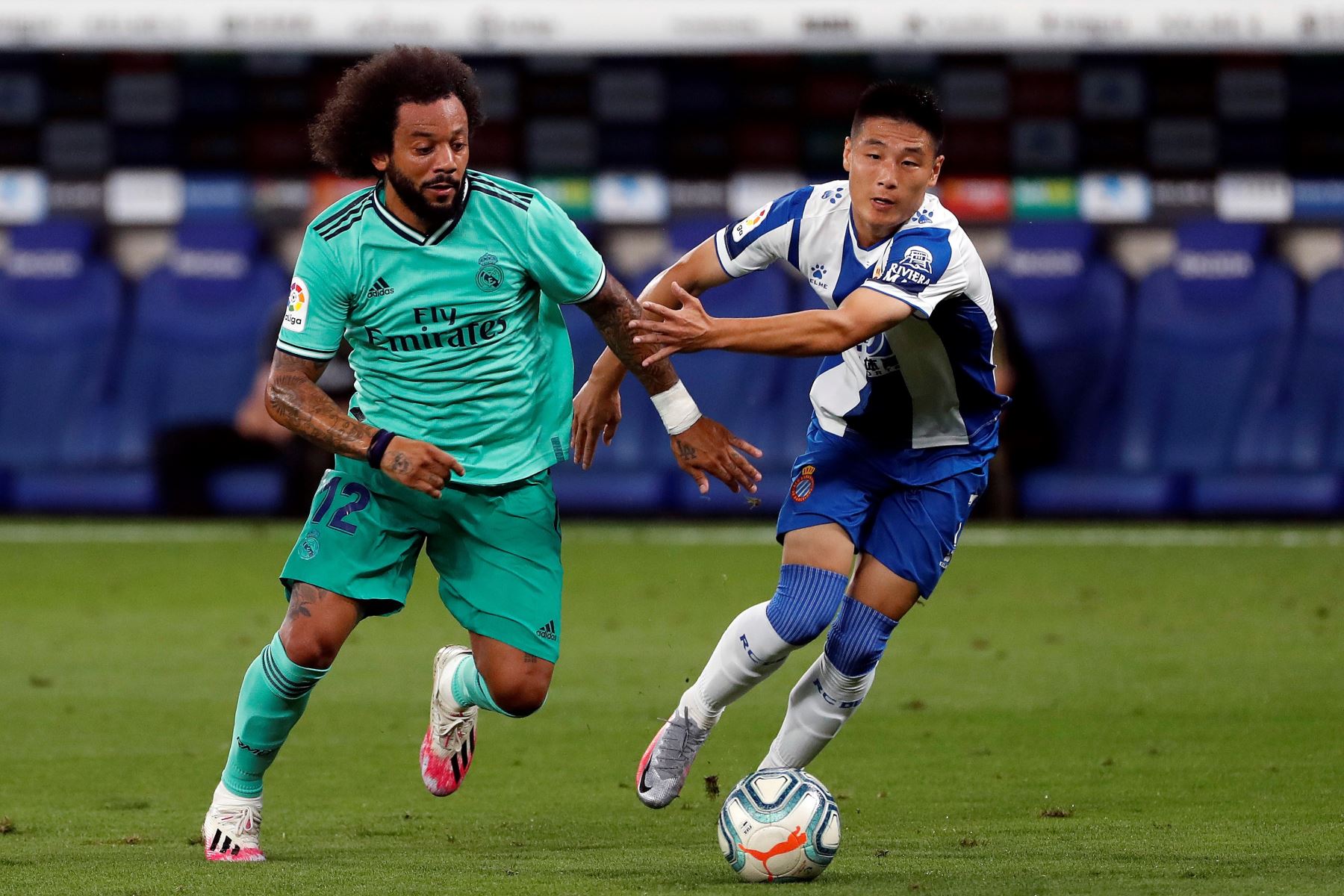 El centrocampista chino del Espanyol, Wu Lei, pelea por el control del balón con el defensa brasileño del Real Madrid, Marcelo Vieira, durante el partido correspondiente a la jornada 32 de LaLiga Santander. Foto: EFE