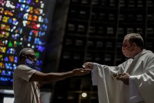 Un hombre es visto mientras recibe la comunión en una iglesia durante la celebración de una eucaristía en Río de Janeiro (Brasil). Foto: EFE