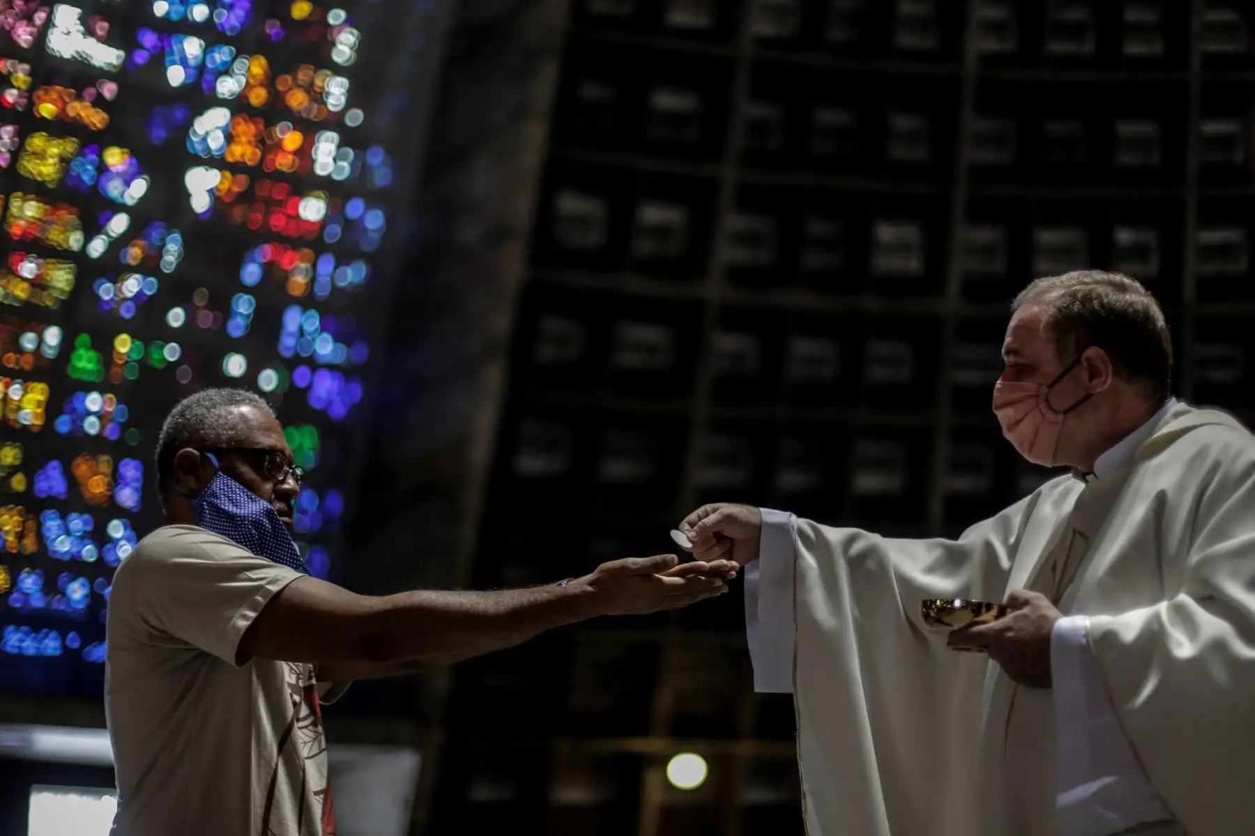 Un hombre es visto mientras recibe la comunión en una iglesia durante la celebración de una eucaristía en Río de Janeiro (Brasil). Foto: EFE