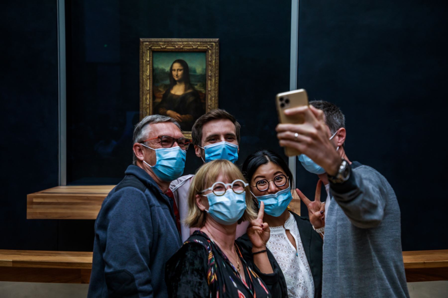 Los visitantes con mascarillas toman fotografías frente a la pintura de Leonardo da Vinci La Gioconda (Mona Lisa), en el Museo del Louvre en París, Francia. Foto: EFE