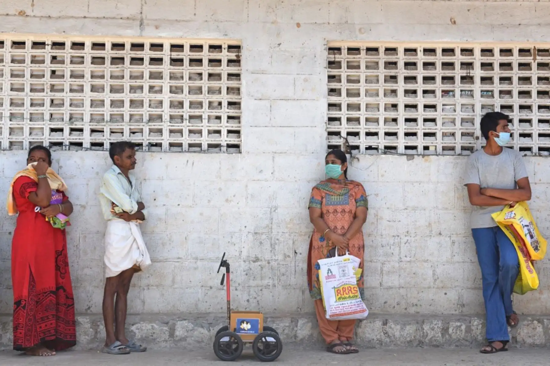 El ingeniero indio Karthik Velayutham usa su robot en una cola para esperar su turno fuera de una tienda de raciones en Coimbatore. Foto: AFP