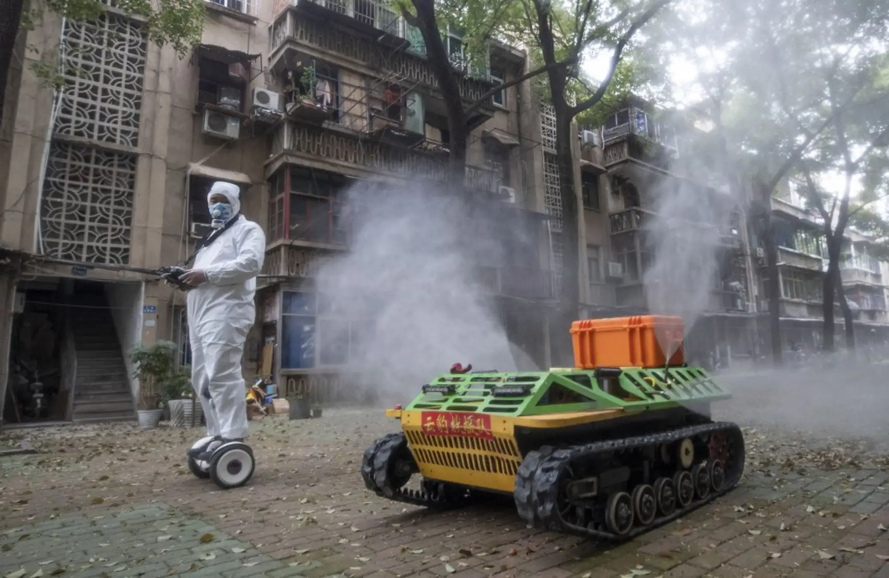 Un voluntario opera un robot de desinfección controlado a distancia para desinfectar un área residencial en medio del brote de coronavirus COVID-19 en Wuhan. Foto: AFP