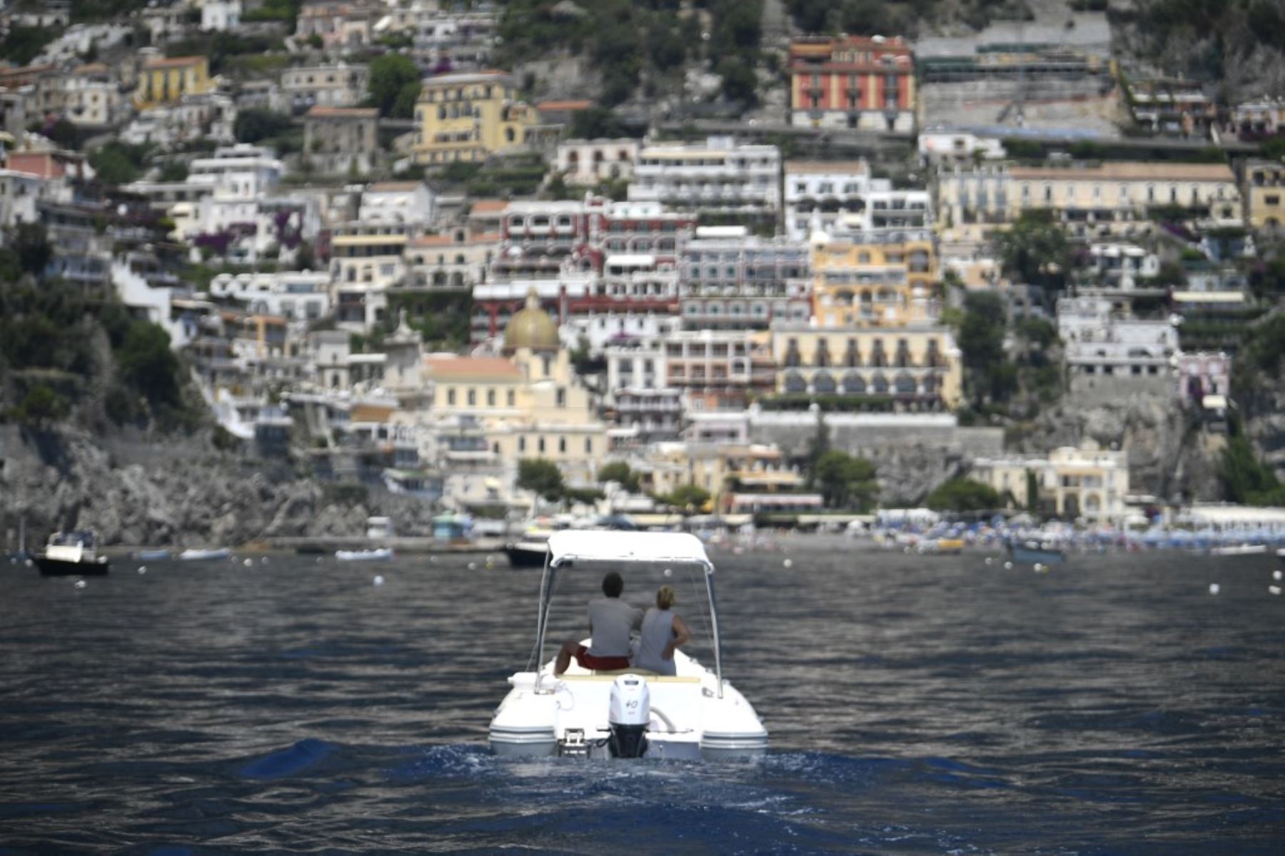 Una vista muestra un barco que navega frente a la aldea de Positano, en la costa de Amalfi, en el sur de Italia. Foto: AFP
