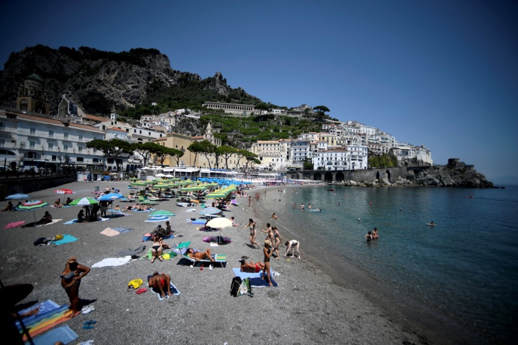 Turistas y residentes toman el sol y nadan en una playa de Amalfi en la costa de Amalfi, en el sur de Italia. Foto: AFP