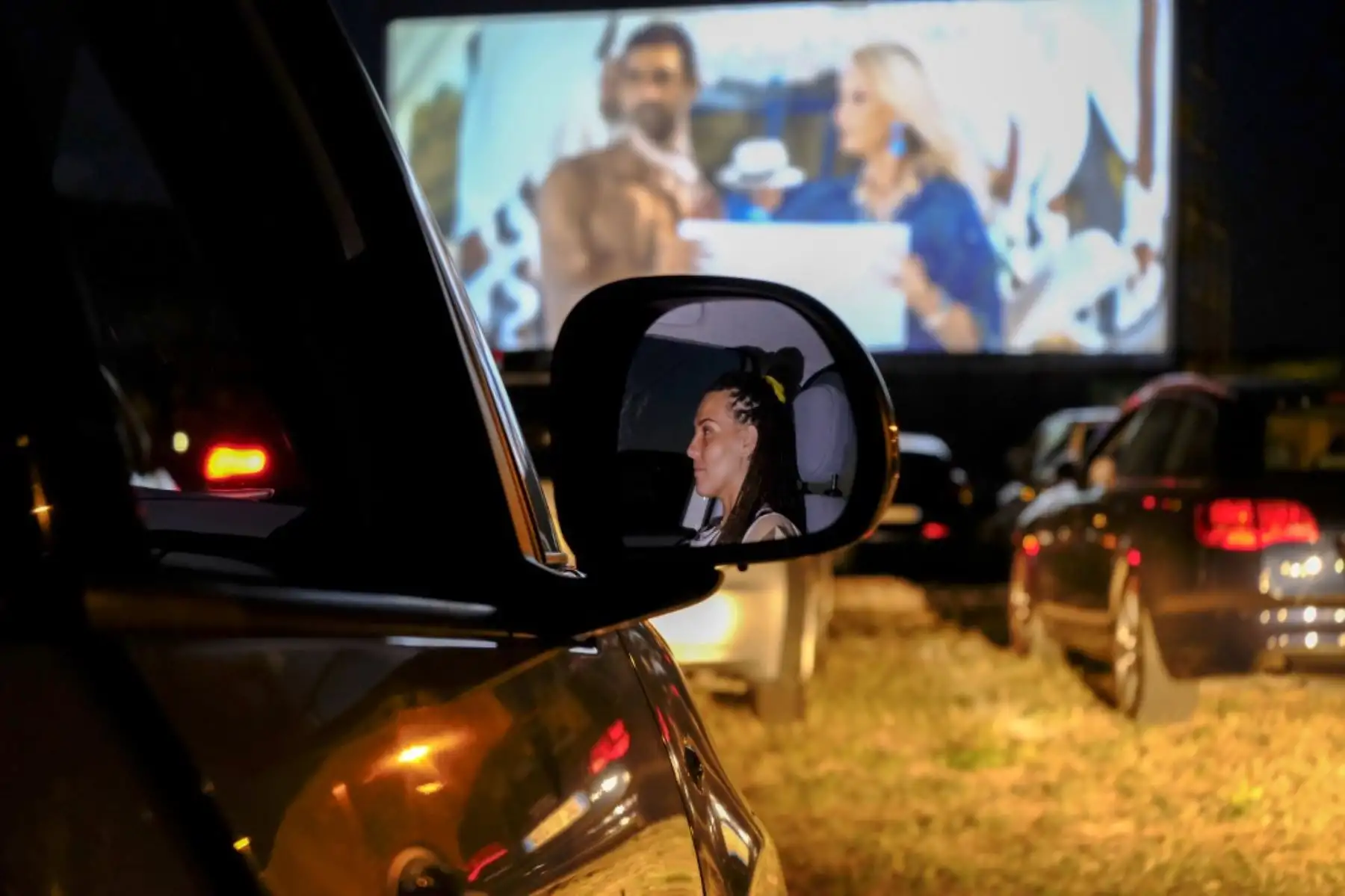 Una mujer mira la comedia italiana "Tolo Tolo" dirigida por Checco Zalone en la noche de apertura del autocine más grande de Europa 