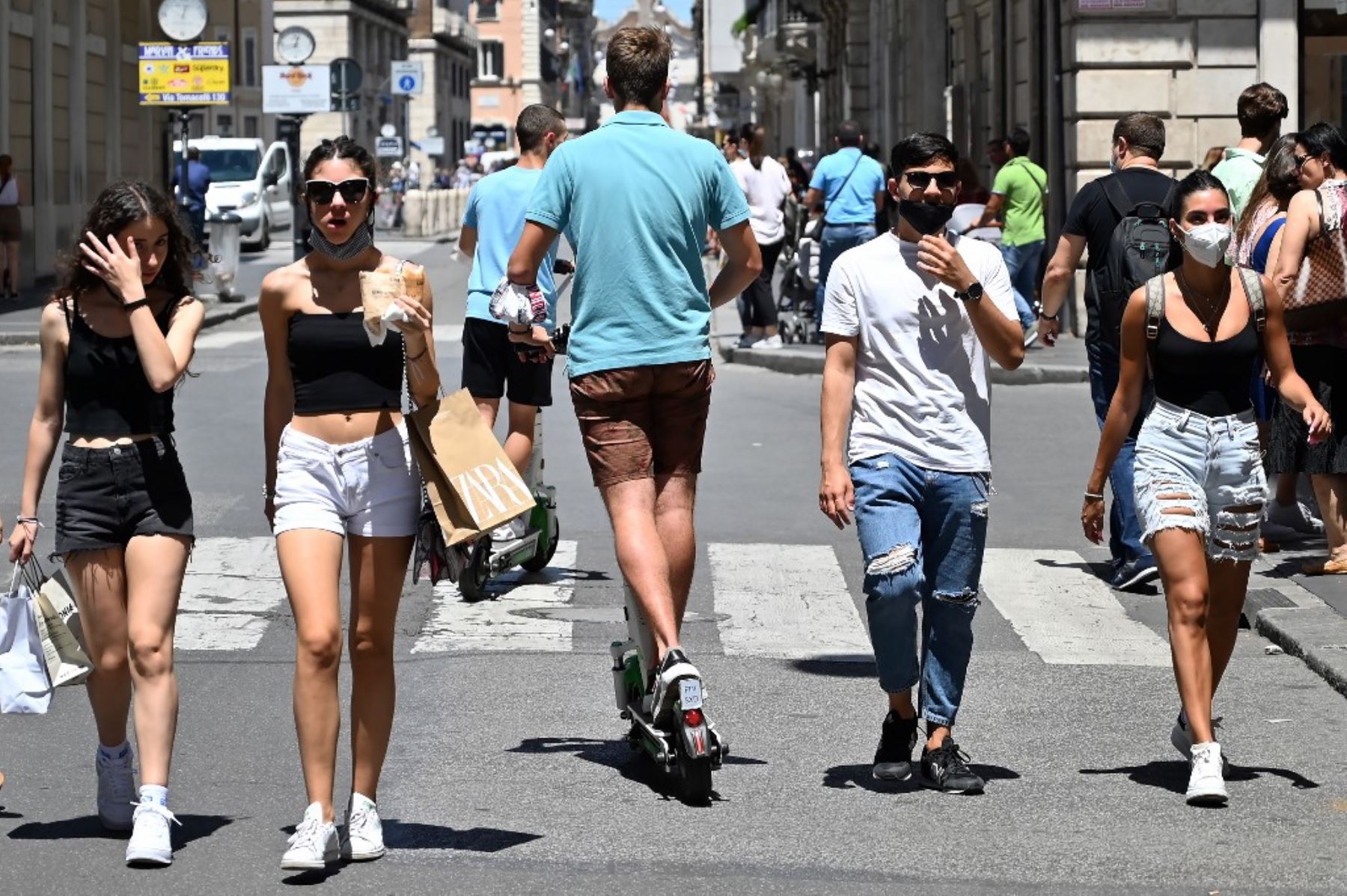 Los jóvenes viajan en scooters eléctricos compartidos a través de la parte peatonal de la calle comercial principal Via del Corso en Roma. Foto: AFP